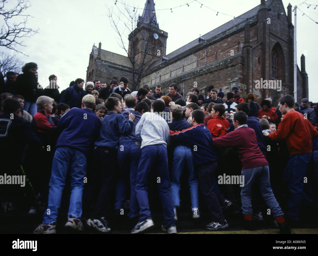 dh The Ba KIRKWALL ORKNEY Boys Capodanno Ba in Broad Street cattedrale di St Magnus giovani bambini scozia bambini calcio Foto Stock