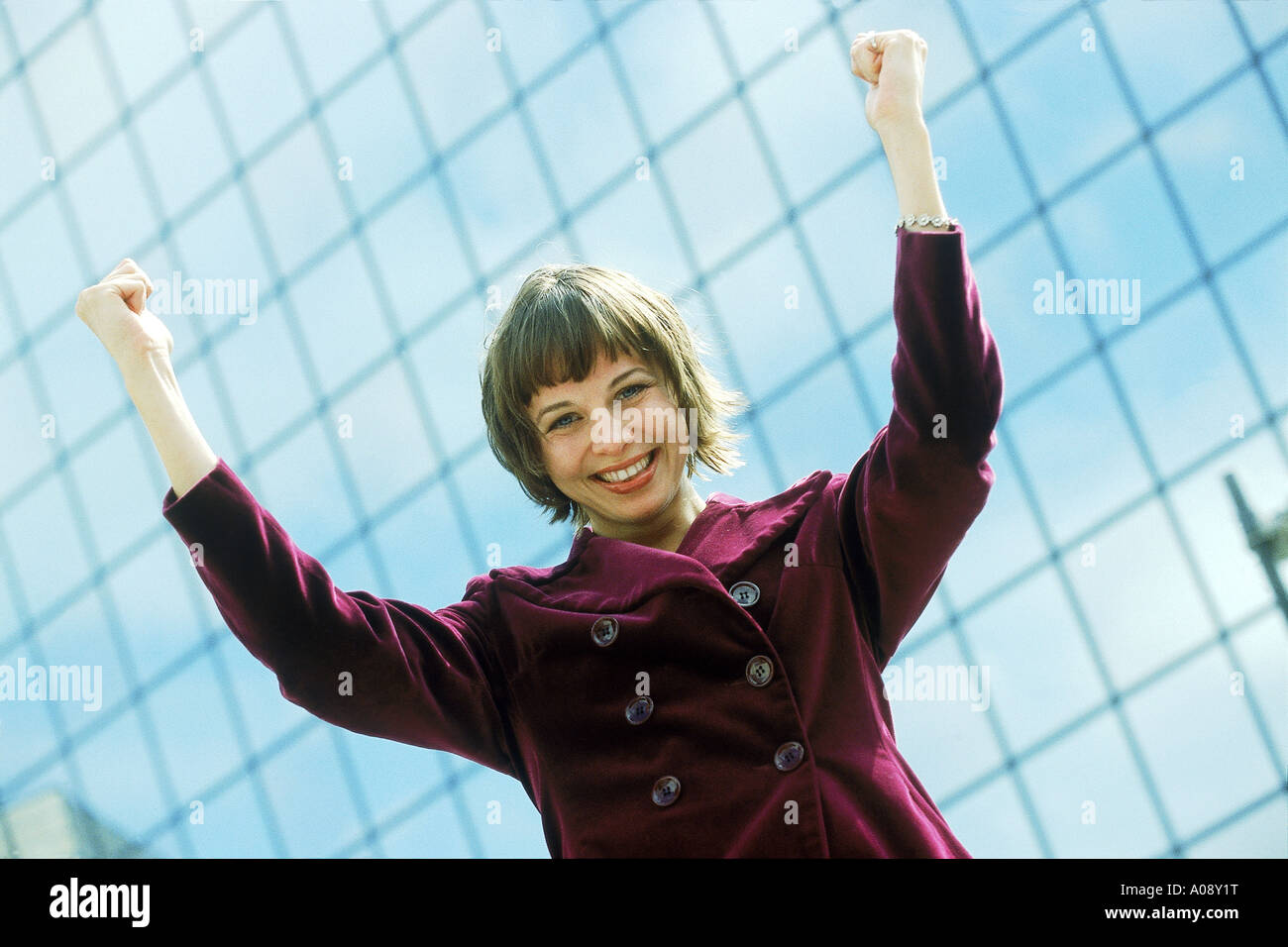 Ritratto di giovane imprenditrice alzando le braccia in eccitazione Foto Stock