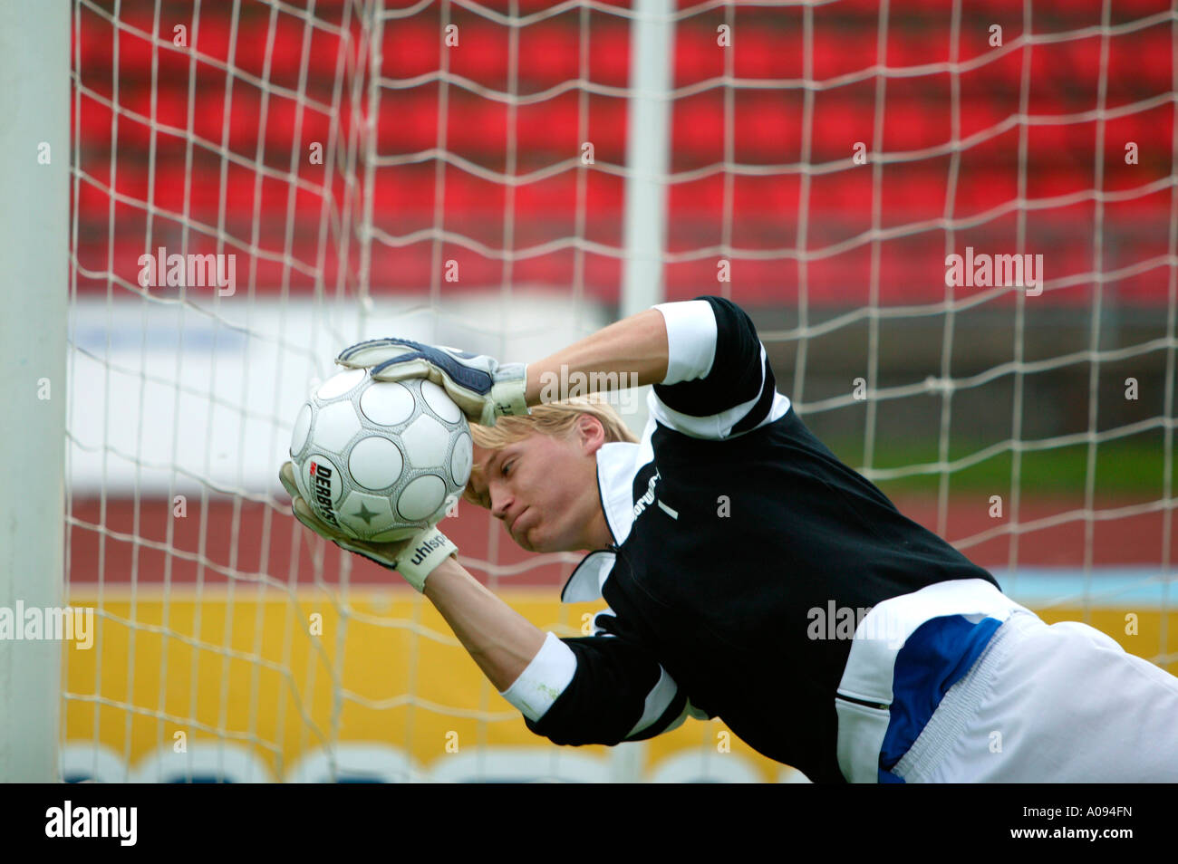 Torwart Fussballspieler haelt den Ball, giocatore di football goalkeeper mantenendo obiettivo Foto Stock