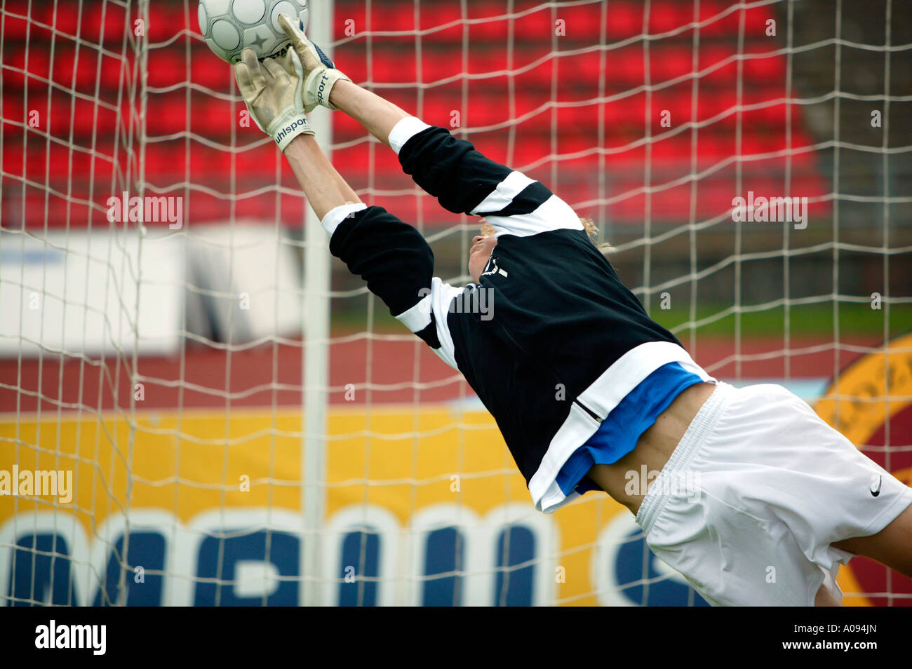 Torwart Fussballspieler haelt den Ball, giocatore di football goalkeeper mantenendo obiettivo Foto Stock