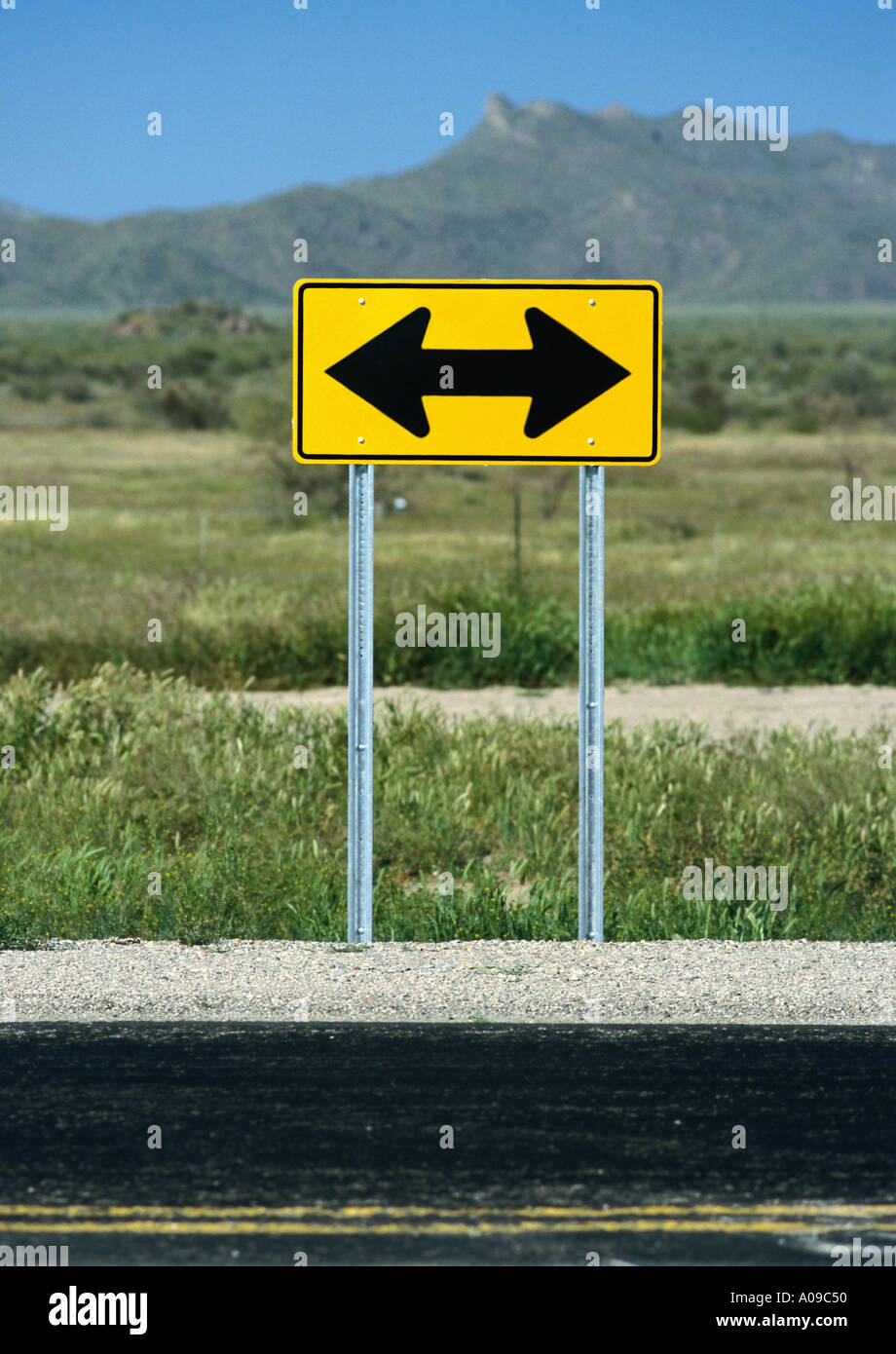 Giallo deve girare a sinistra o a destra strada rurale segno Foto Stock