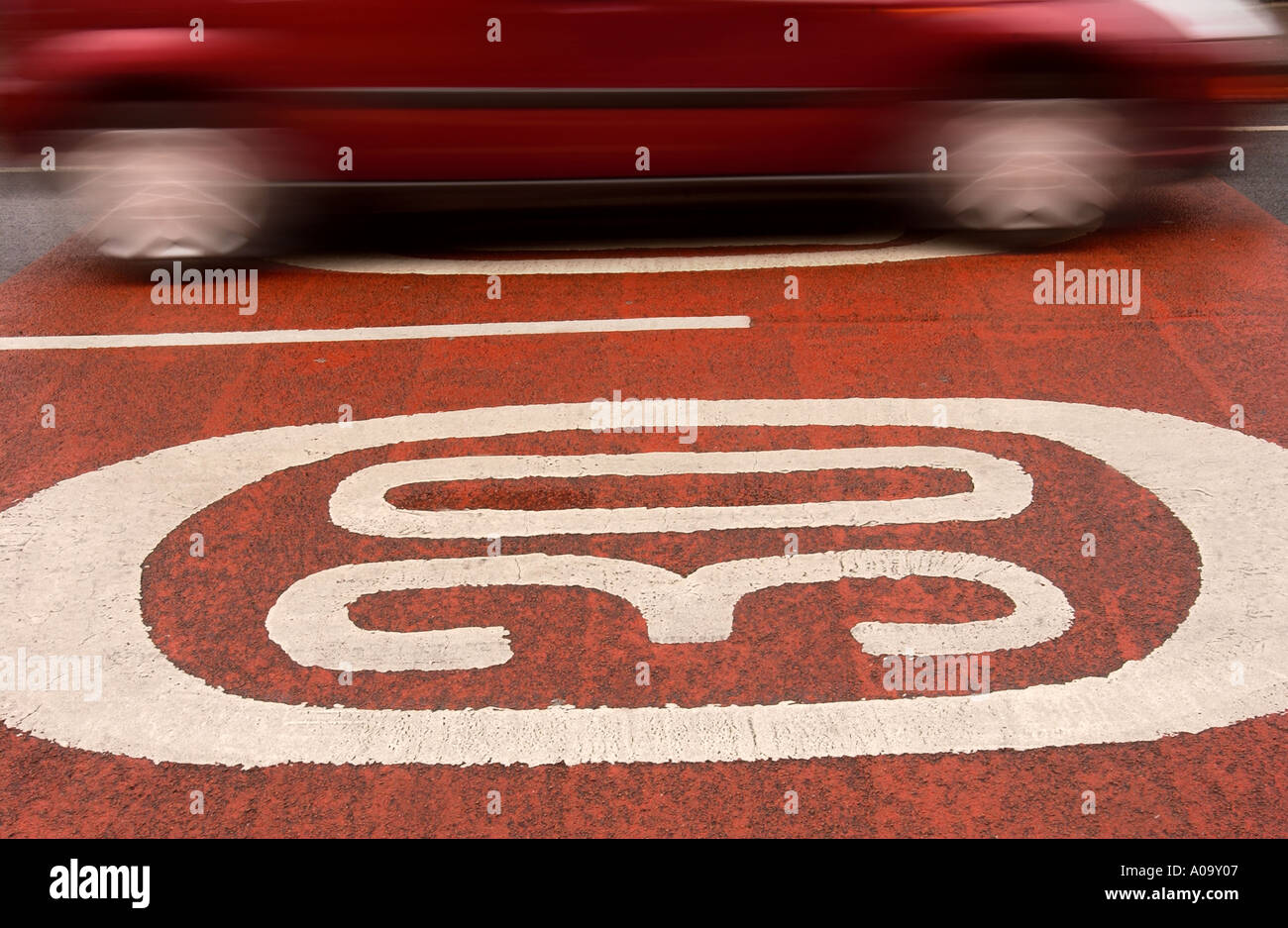Una macchina passa oltre trenta miglia per ora gli avvisi di velocità dipinta sul manto stradale Regno Unito Foto Stock