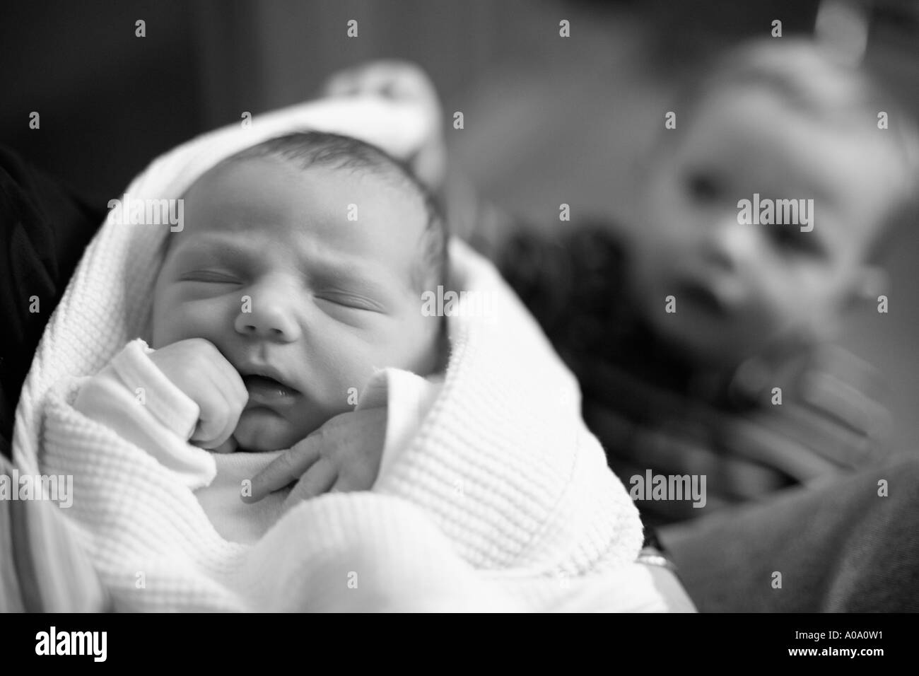 I neonati con 18 mese vecchio fratello in background. Foto Stock