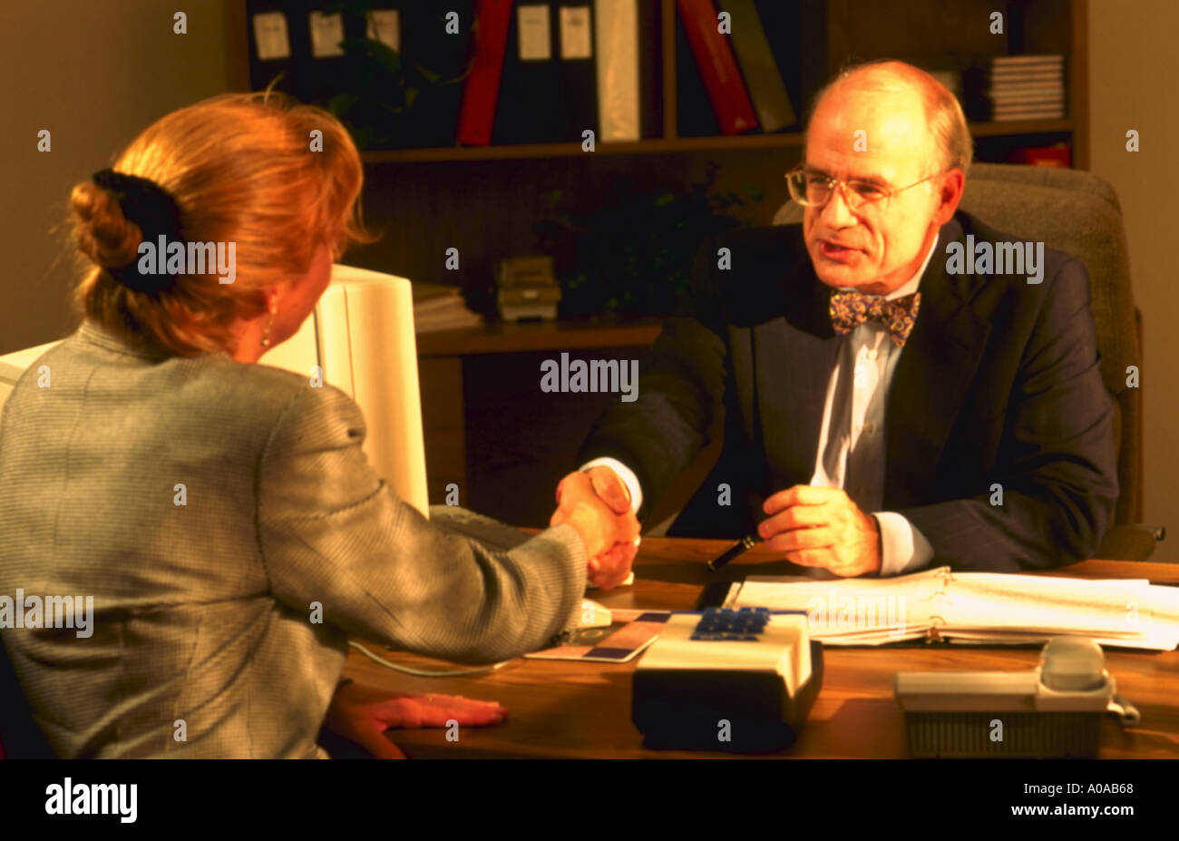 Imprenditore e business donna stringono le mani sulla scrivania in ufficio Foto Stock