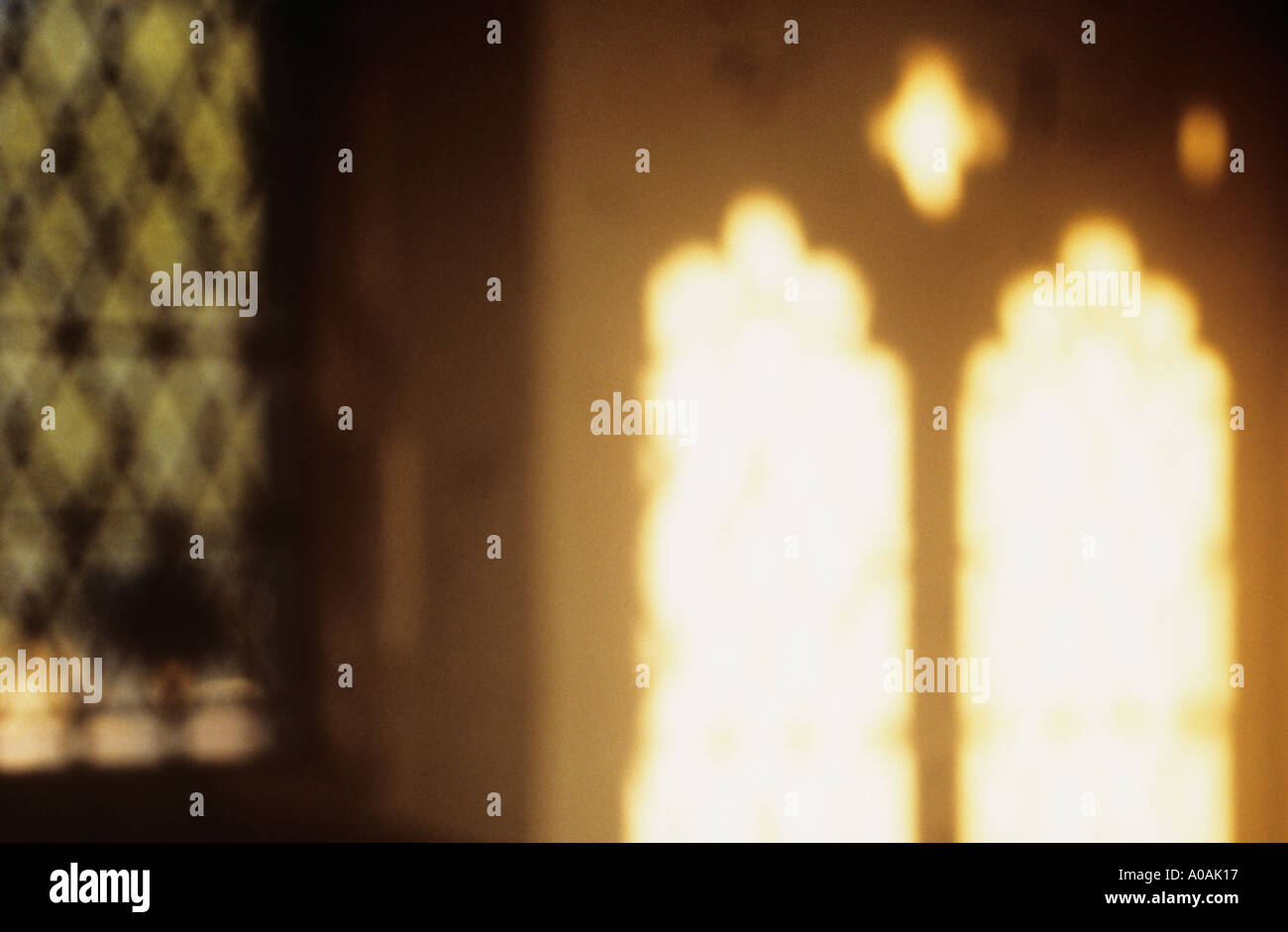 Defocussed proiezione di una chiesa finestra su una normale parete crema di sera Foto Stock