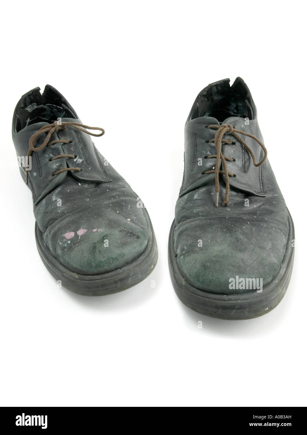 Due piedini di sinistra; 2 piede sinistro; vecchie scarpe; pizzi; confortevole; poveri; usurati; usurati; nero calzatura; nero scarpe; vernice;sfondo bianco Foto Stock