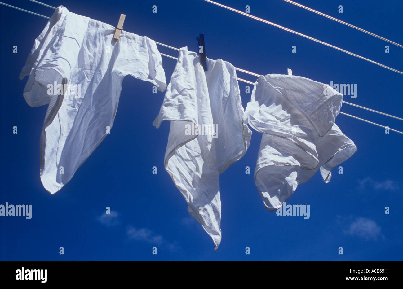 Chiudere fino a tre fazzoletti bianchi soffiando nel sole e brezza sul  lavaggio-linea sotto il profondo blu del cielo Foto stock - Alamy