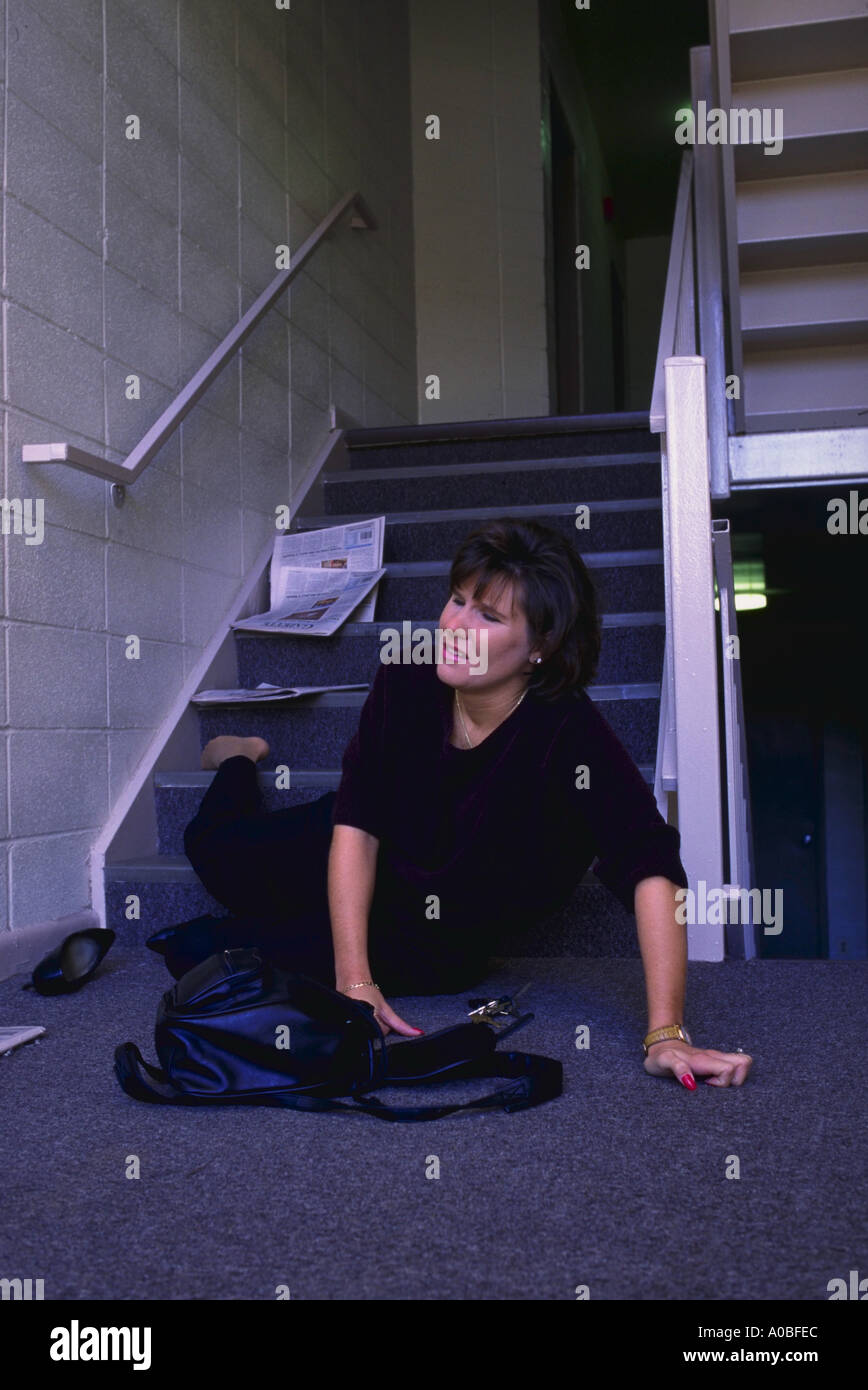 Donna cadere giù per le scale del condominio Foto Stock