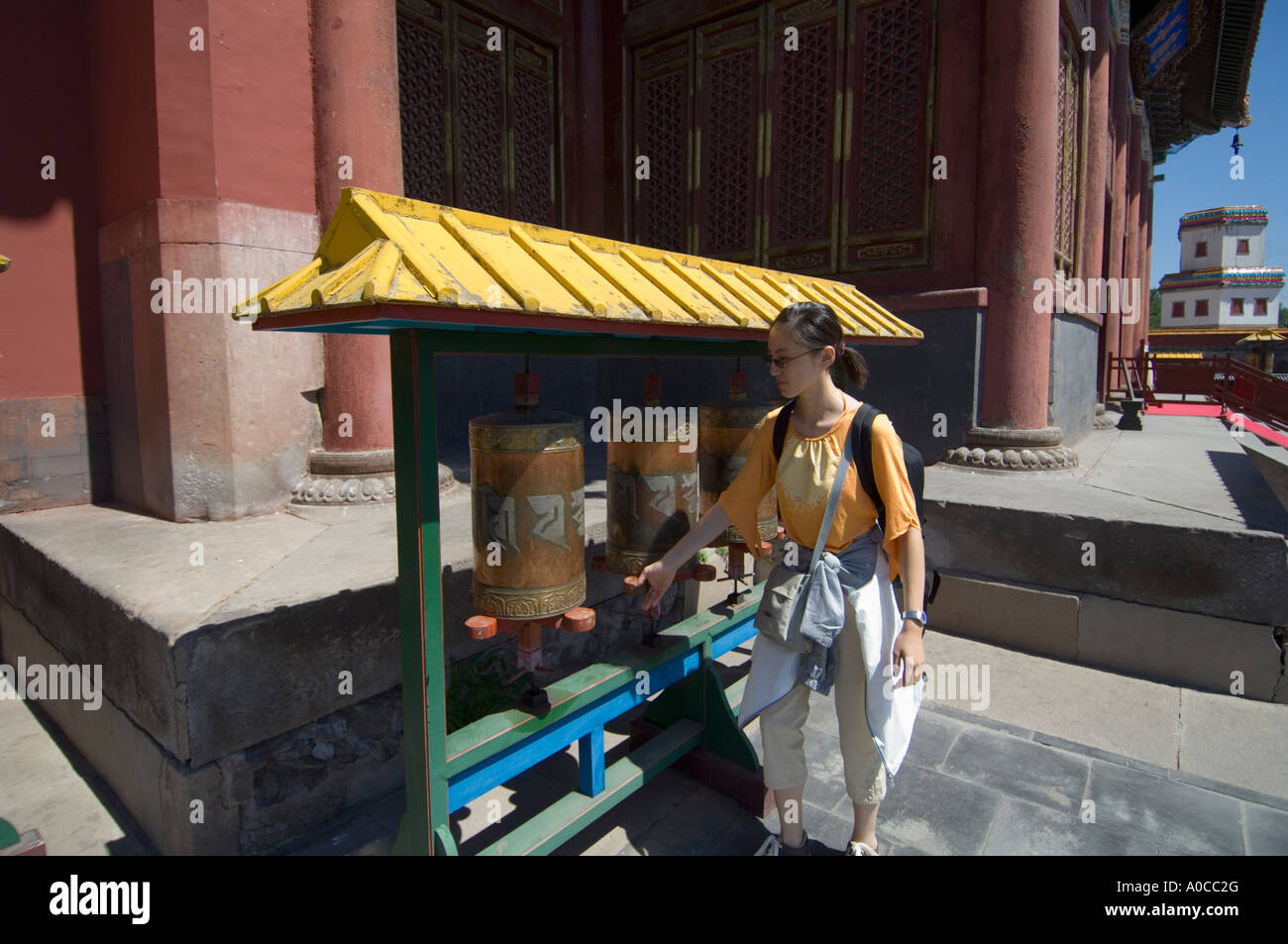 Un visitatore girando le ruote della preghiera a puning si (Tempio di Pace universale) in Chengde sul sito del Patrimonio mondiale Foto Stock