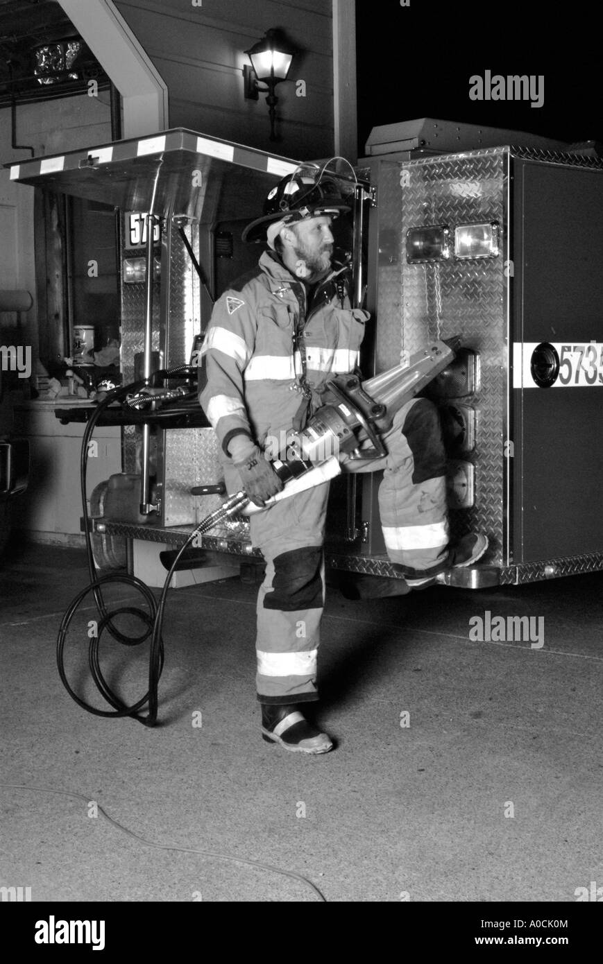 Volunteer fire fighter dall'Occidental volontario dei Vigili del Fuoco si erge accanto alla squadra di salvataggio con le ganasce della vita Foto Stock