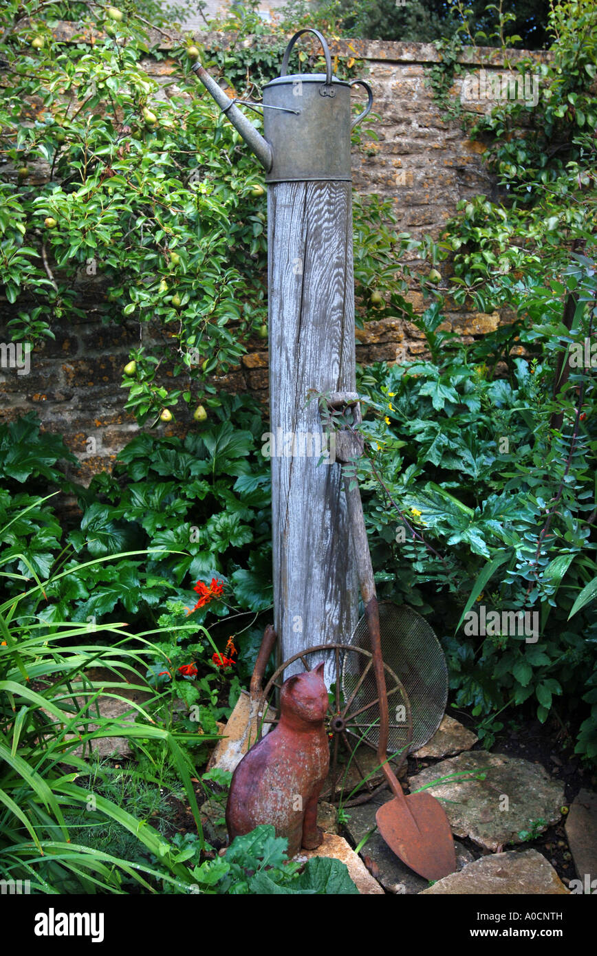 Un singolare giardino scultura con utensili da giardinaggio un palo del telegrafo e ANNAFFIATOIO IN CIMA AL REGNO UNITO Foto Stock