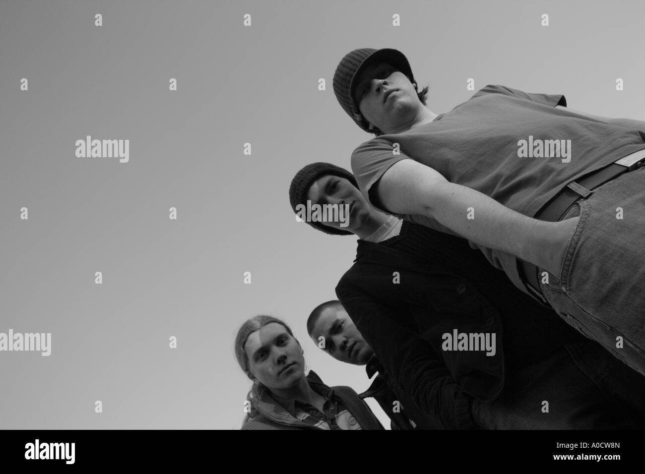 Quattro giovani uomini guardando giù in telecamera Foto Stock