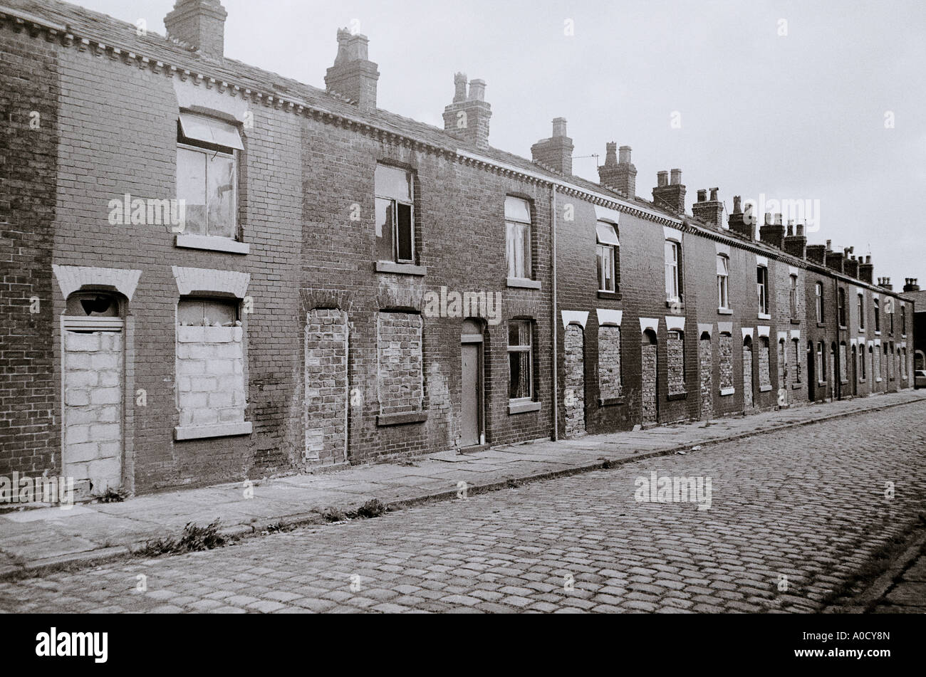 Le difficoltà economiche - una bottiglia di latte al di fuori del solo casa occupata in una strada a Bolton in Inghilterra in Gran Bretagna nel Regno Unito Regno Unito. La povertà Foto Stock