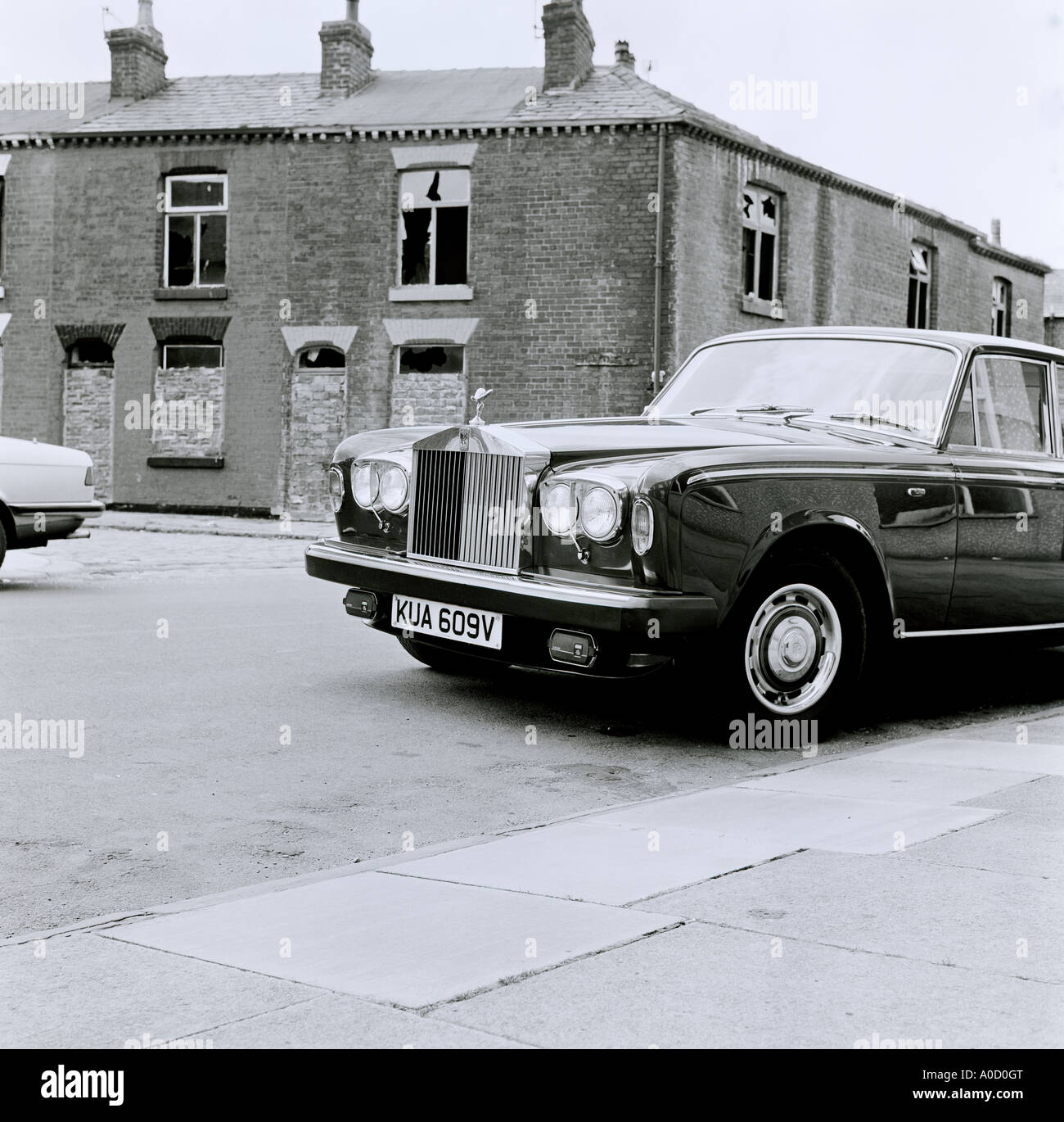 Una Rolls Royce auto in Bolton in Lancashire in Inghilterra in Gran Bretagna nel Regno Unito Regno Unito. Baraccopoli povertà ricchezza vetture scadenti Ghetto disuguaglianza Foto Stock