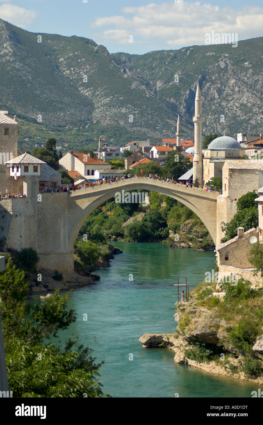 I turisti di guardare un uomo su di tuffarsi dal nuovo vecchio ponte nel fiume Neretva Mostar Bosnia Erzegovina Foto Stock