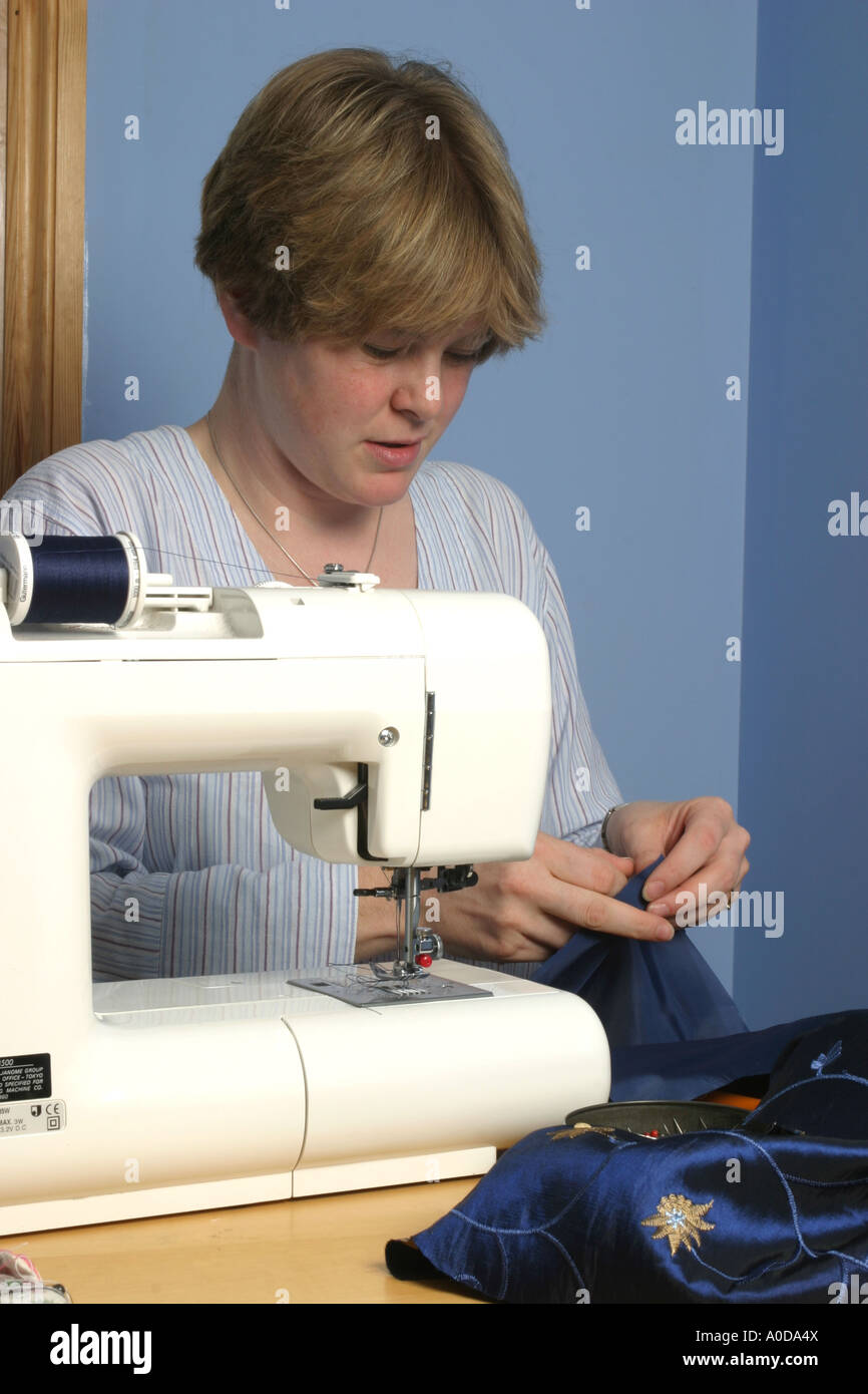 Una donna con le mani in mano lavorando a macchina da cucire. Foto Stock