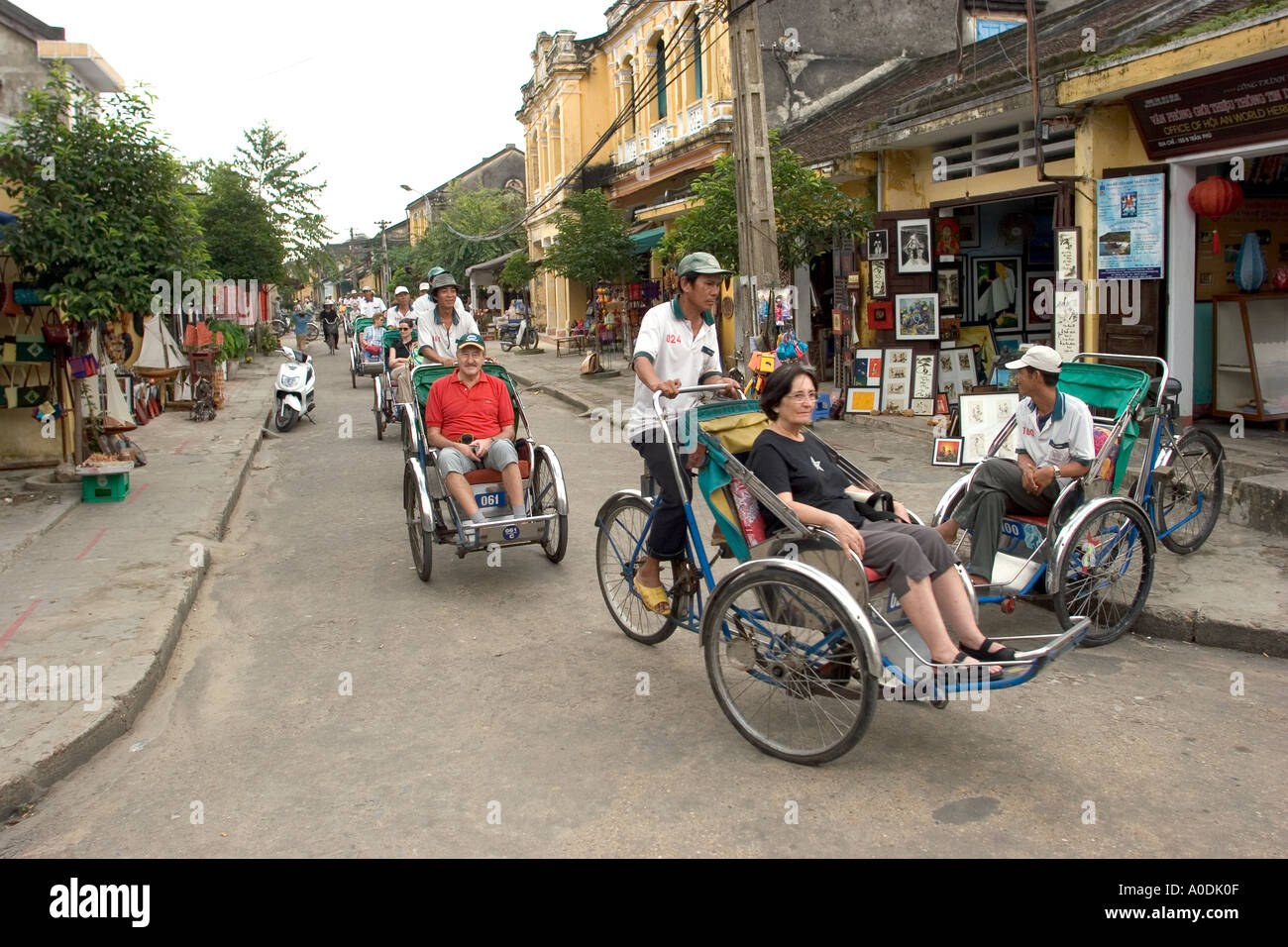 Il Vietnam centrale di Hoi An Old Town line di turisti occidentali sul ciclo cyclo rickshaw tour Foto Stock