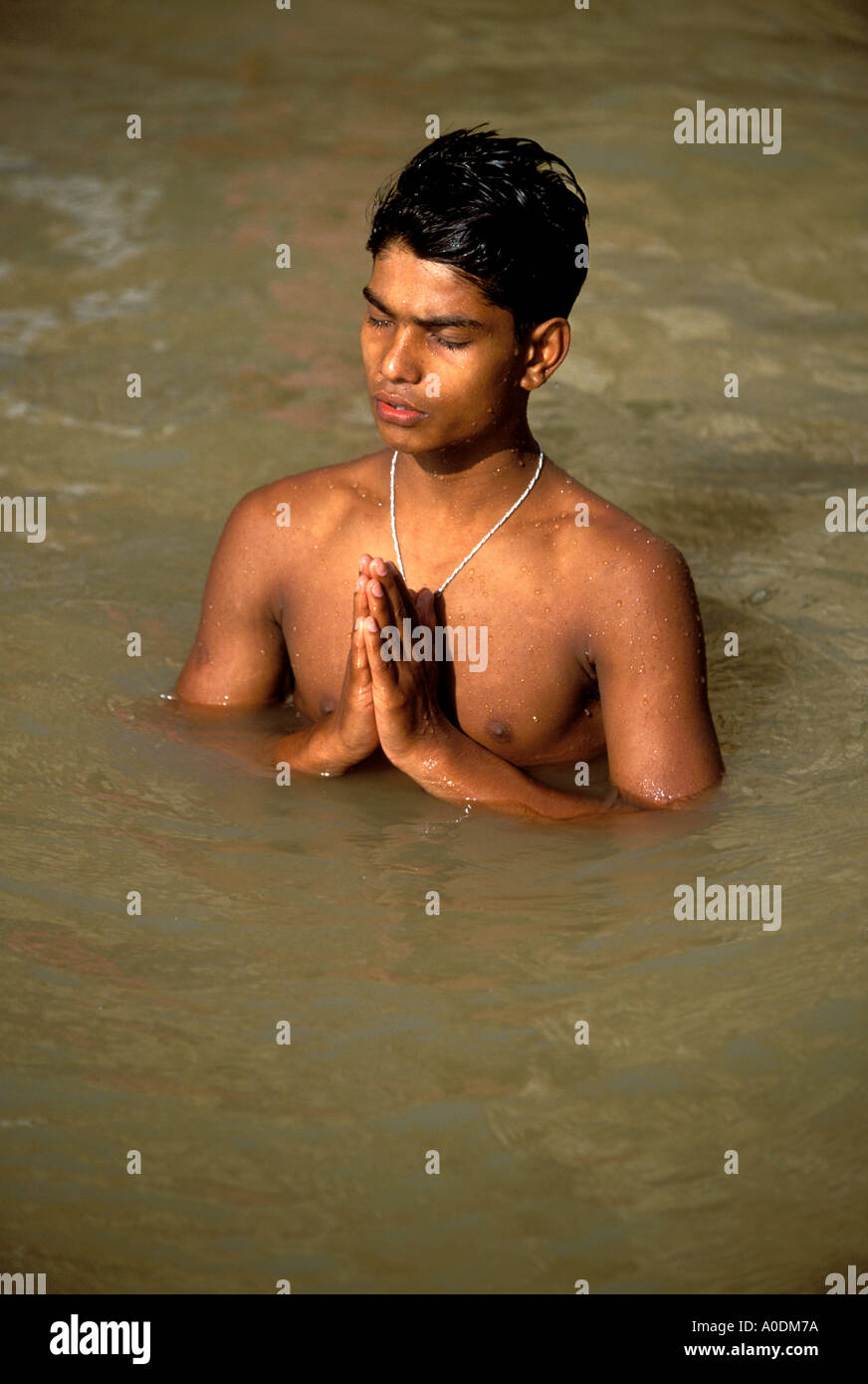 Indian giovane la balneazione e la preghiera nel sacro Gange fiume vicino a Varanasi Ghat Induismo Uttar Pradesh, India Foto Stock