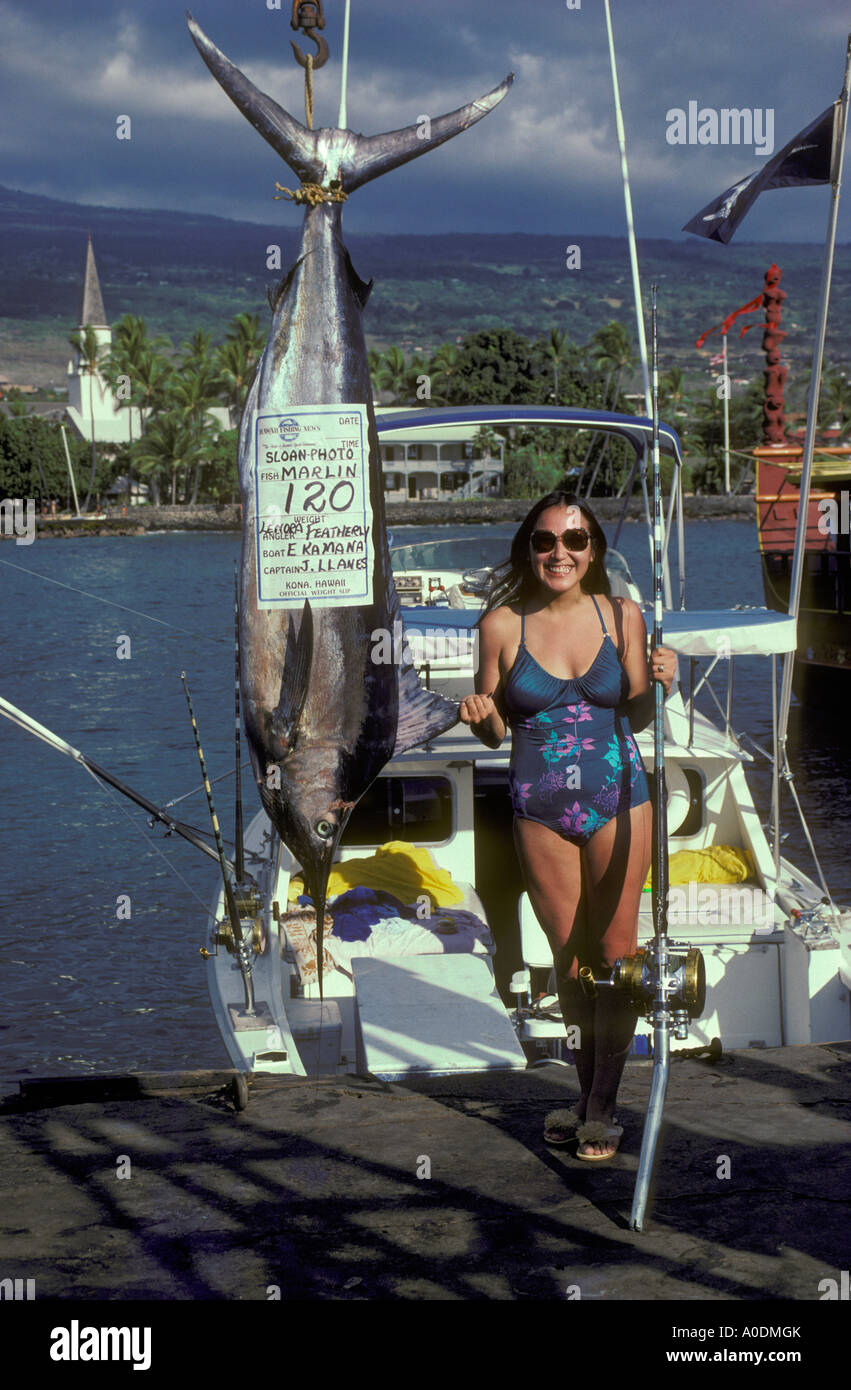 Donna che posano per una foto con il Marlin ha catturato su sportfishing charter imbarcazione KAILUA KONA Hawaii Foto Stock