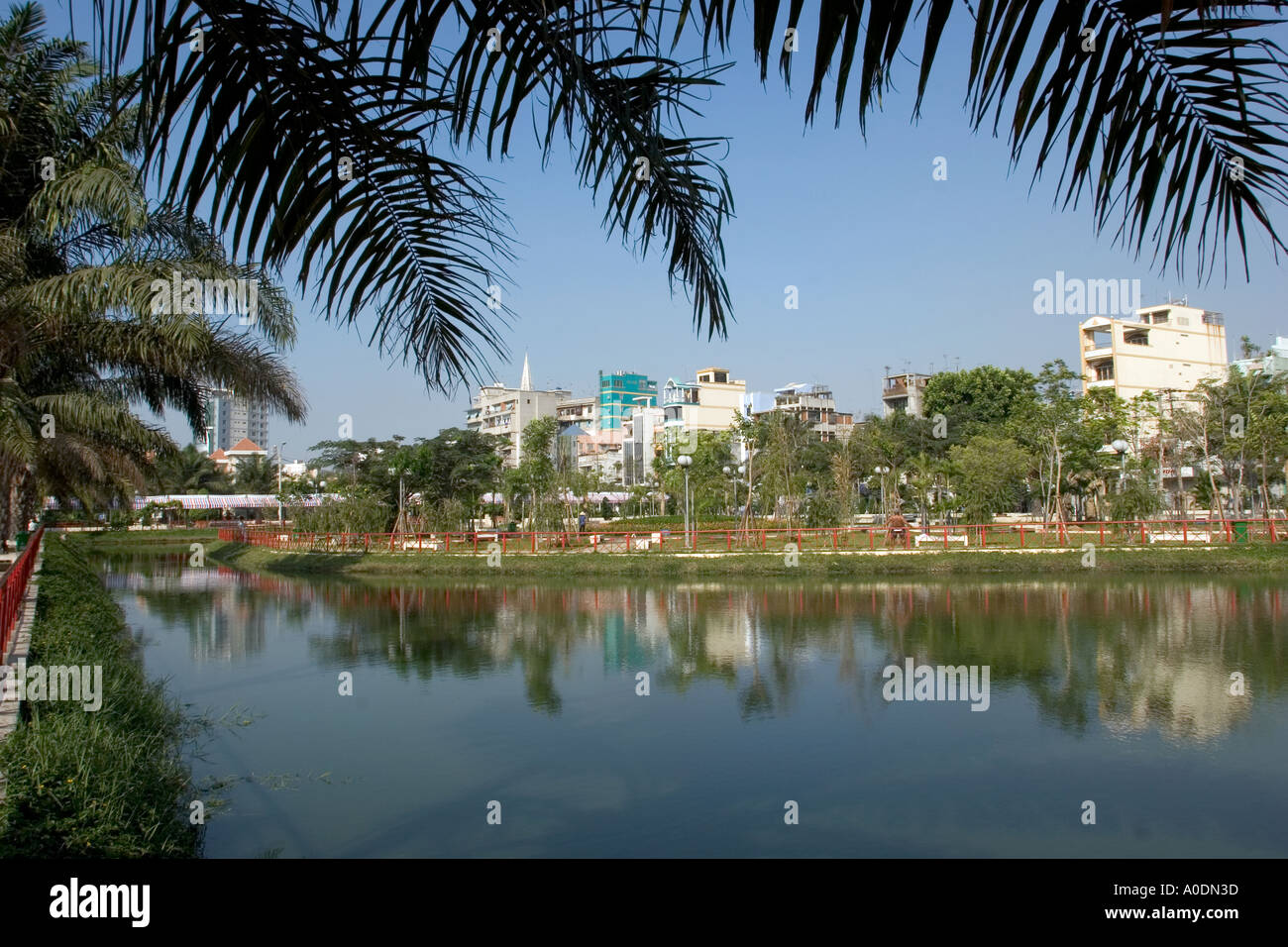 Vietnam Ho Chi Minh City Saigon District 1 parco pubblico case si riflette nel piccolo lago Foto Stock