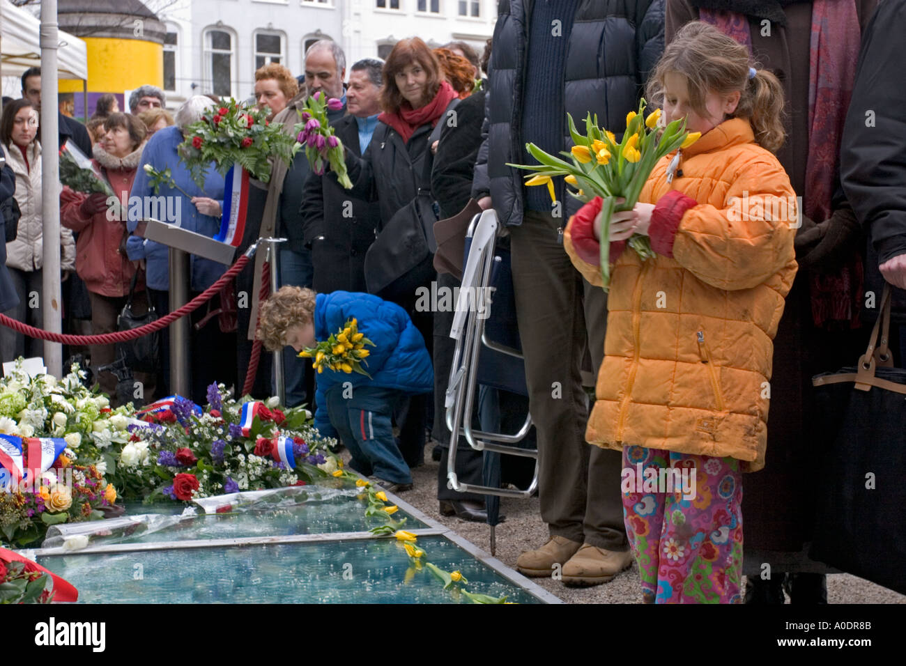 I bambini mettendo fiori sul monumento di Auschwitz in Amsterdam durante la commemorazione dell'anniversario della liberazione del campo Foto Stock