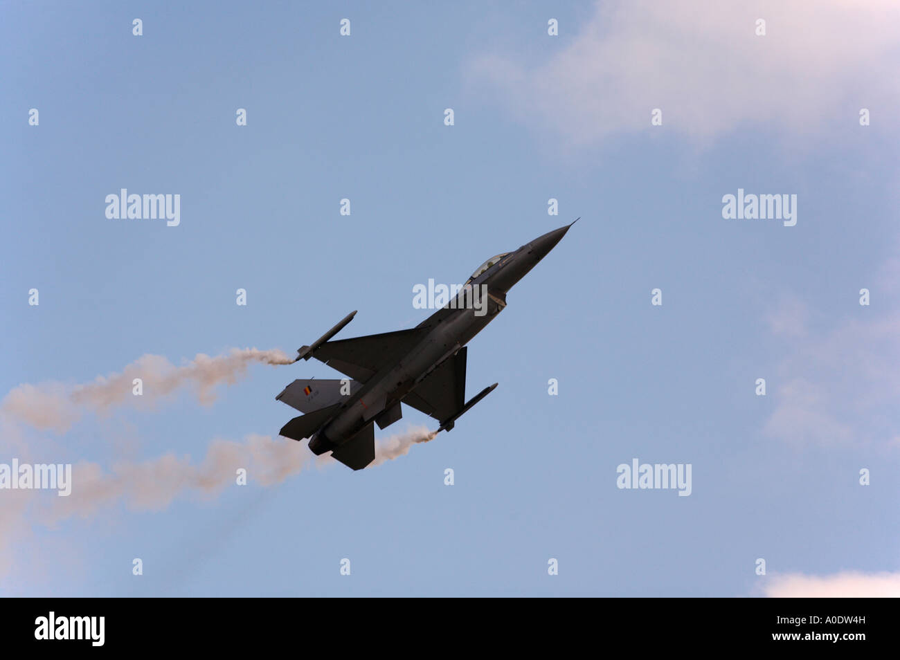 Aviazione belga F16 Fighting Falcon posa sentieri di fumo per simulare lanci di razzi Foto Stock