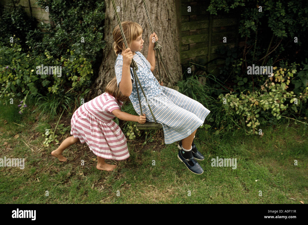 Due ragazze giocando su swing Foto Stock