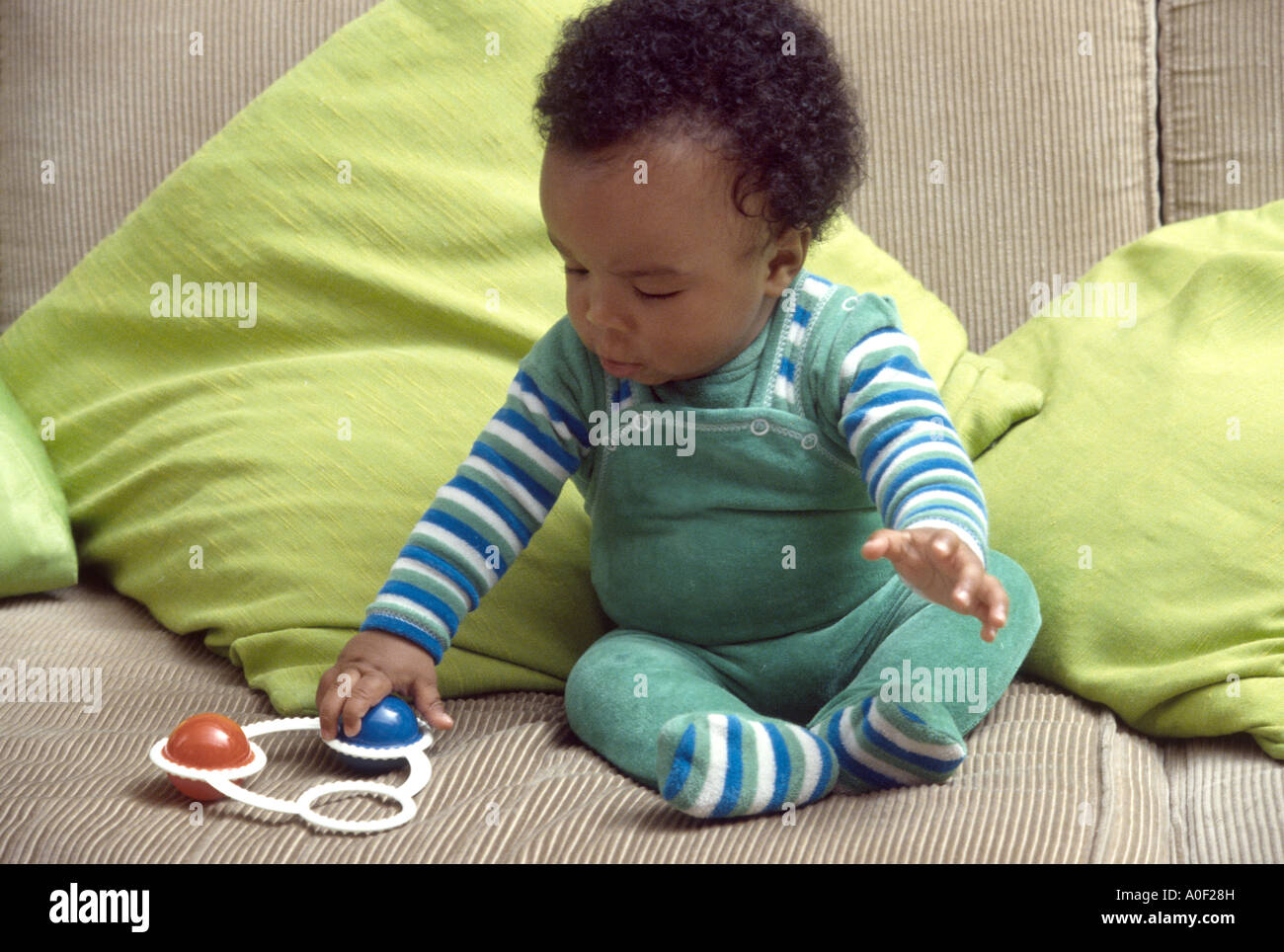 Bambino nero gioca con un sonaglio Foto Stock