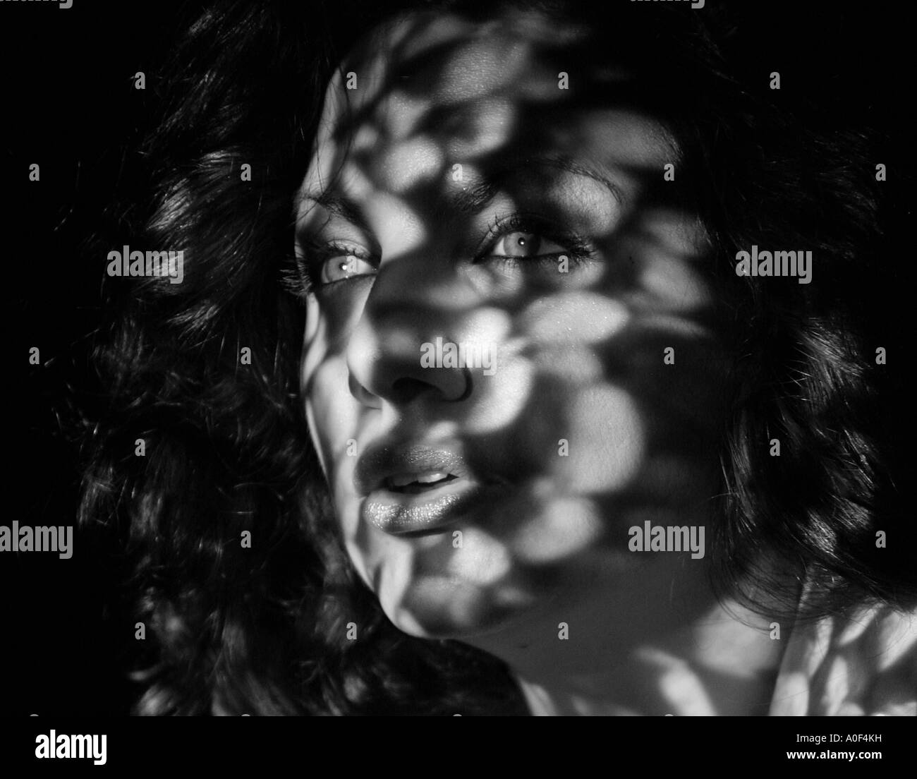 Ritratto monocromatica di una ragazza con le ombre sul viso Foto Stock