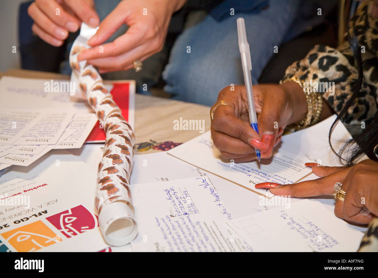 Le donne scrivere cartoline invitando la gente a votare Foto Stock