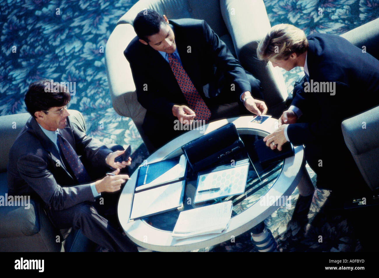 Angolo di alta vista di tre uomini di affari seduti insieme Foto Stock