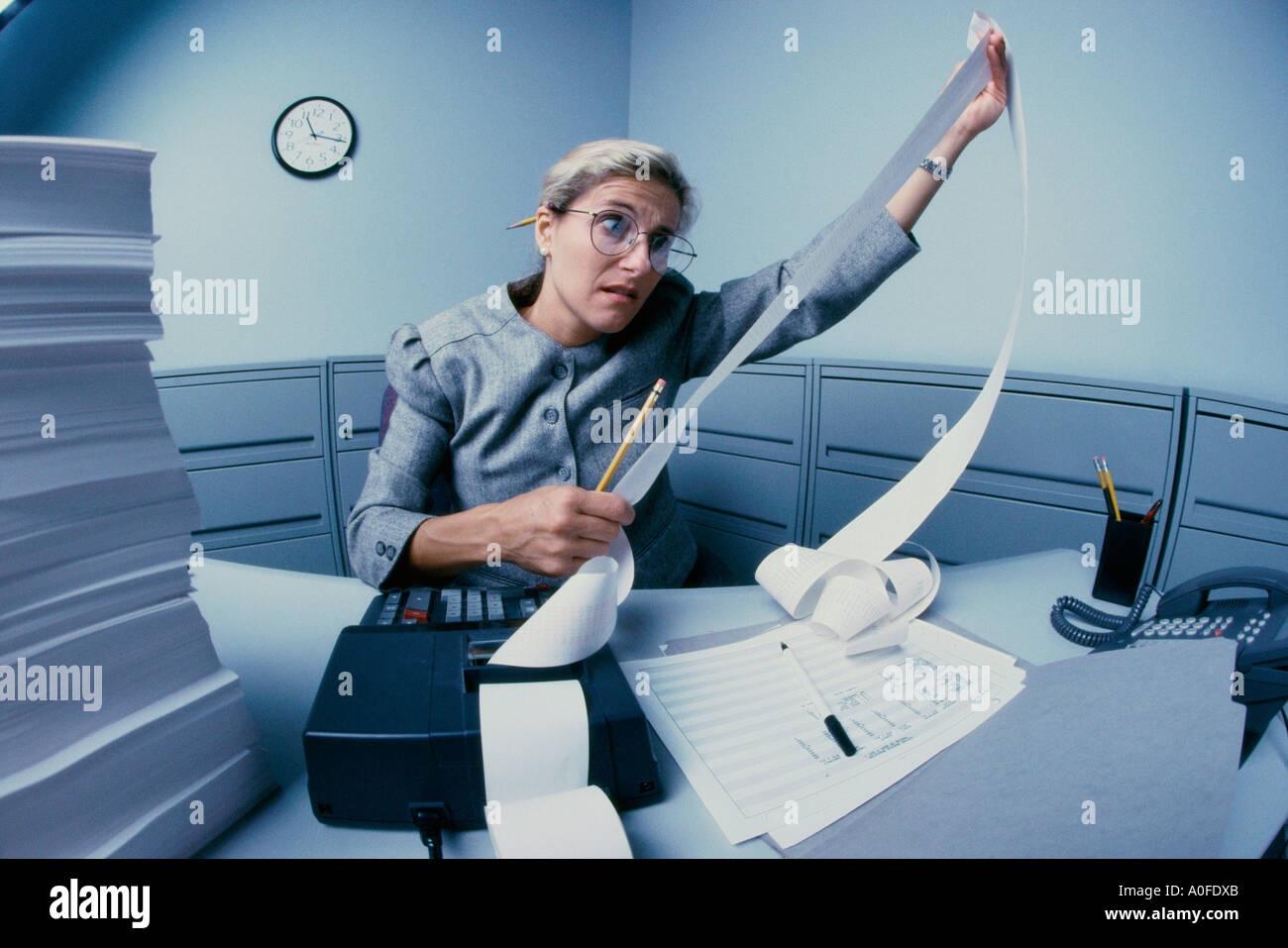 Imprenditrice guardando un aggiunta di macchina il rullo della carta Foto Stock