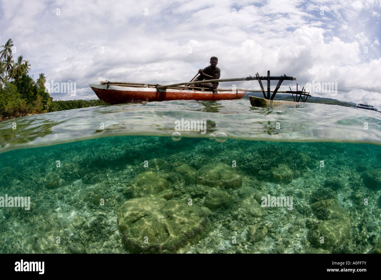 Un pescatore nativo in una canoa outrigger Nuova Bretagna PAPUA NUOVA GUINEA Foto Stock