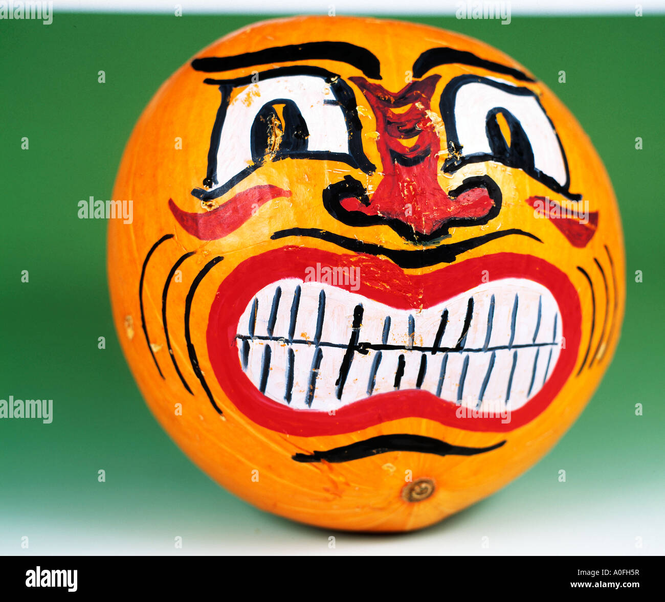 Grande zucca gialla con faccia dipinta si siede in un mans vetrina Foto Stock