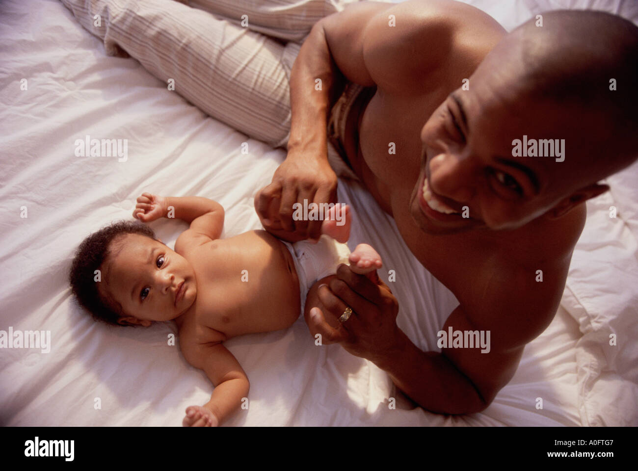 Ritratto di un padre tenendo la sua baby boy i piedi Foto Stock