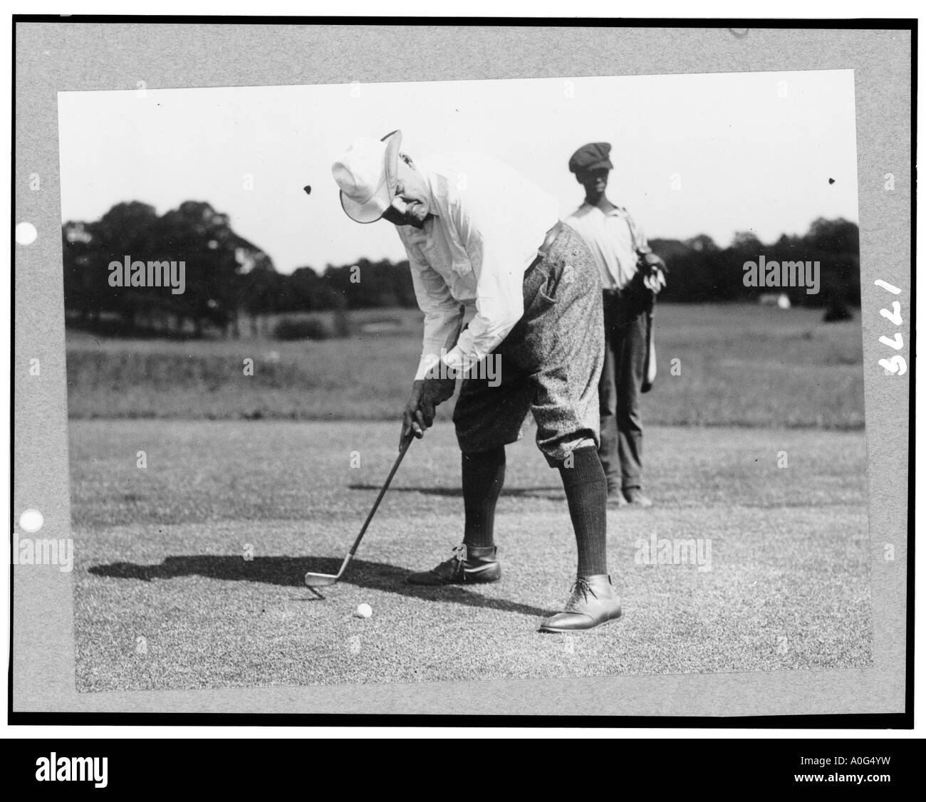 Warren Harding G di piegarsi per colpire la pallina da golf possibilmente in Washington DC Inizio 1920 s Foto Stock