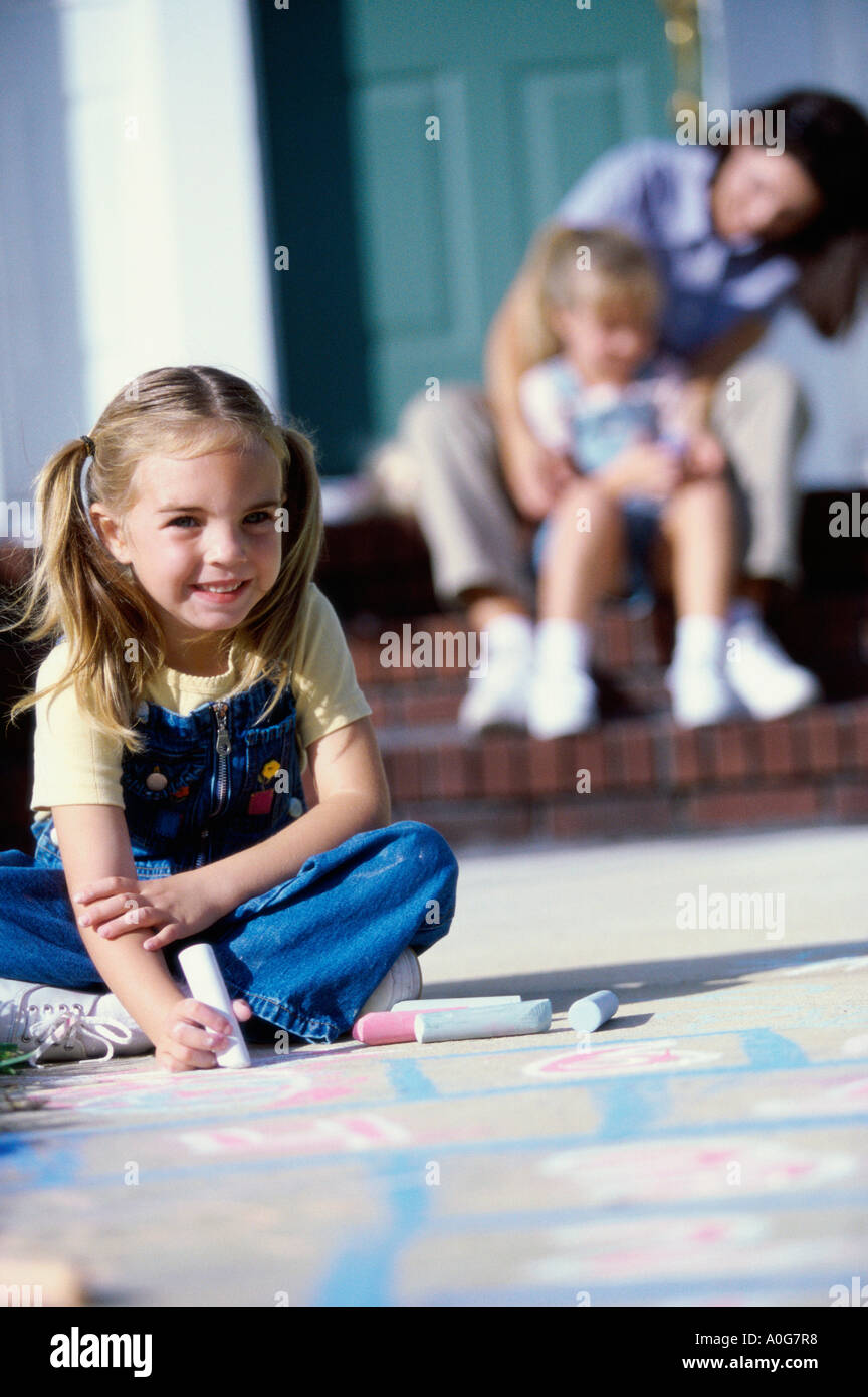 Ritratto di una ragazza disegno sul pavimento con Chalk Foto Stock