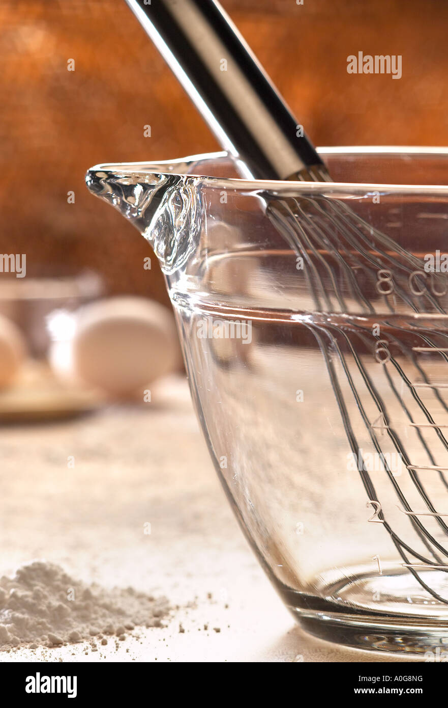 Cucina con la frusta di metallo e di vetro chiaro la coppa di misurazione Foto Stock