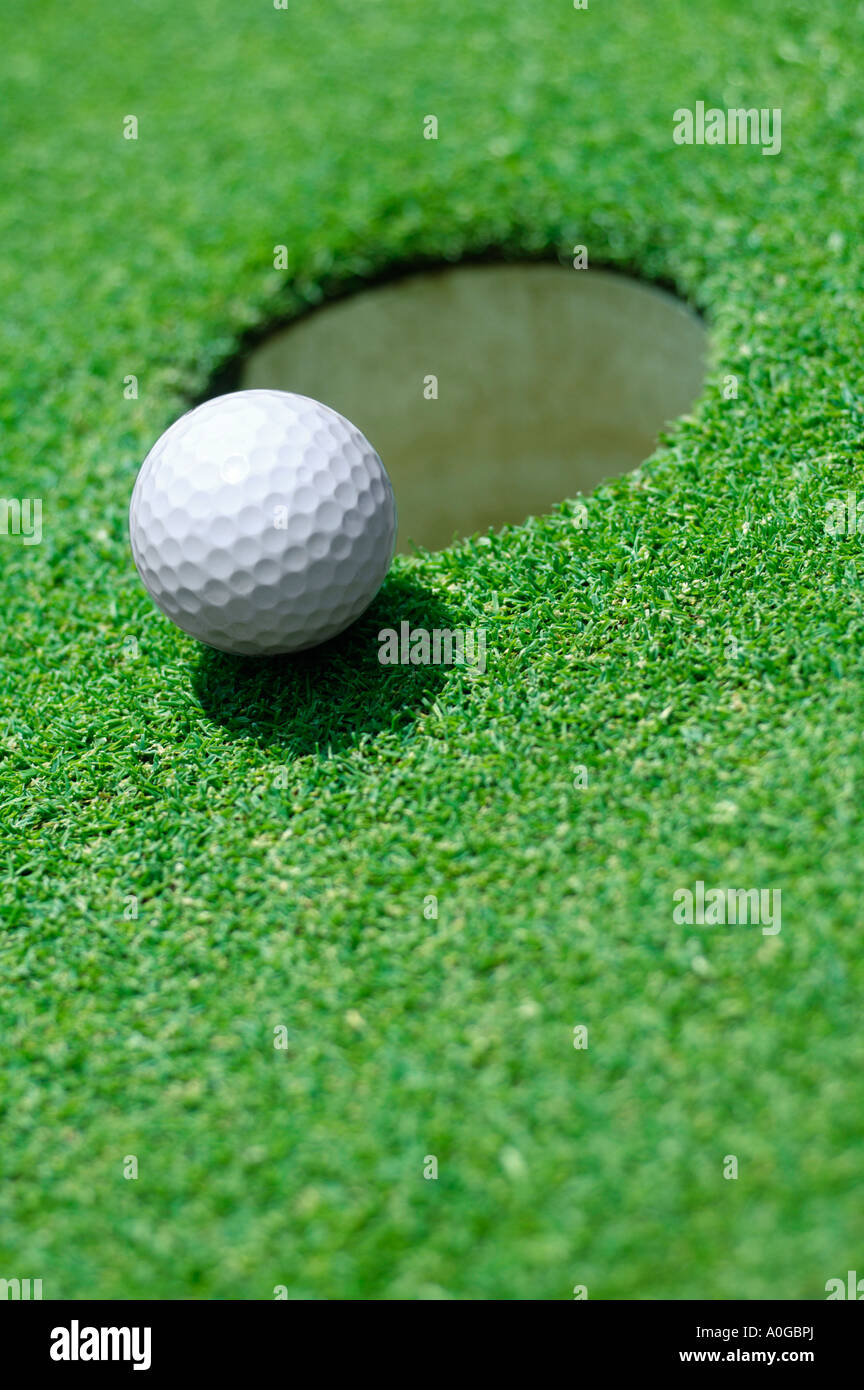 Palla da golf sul bordo del foro sul golf green Foto Stock