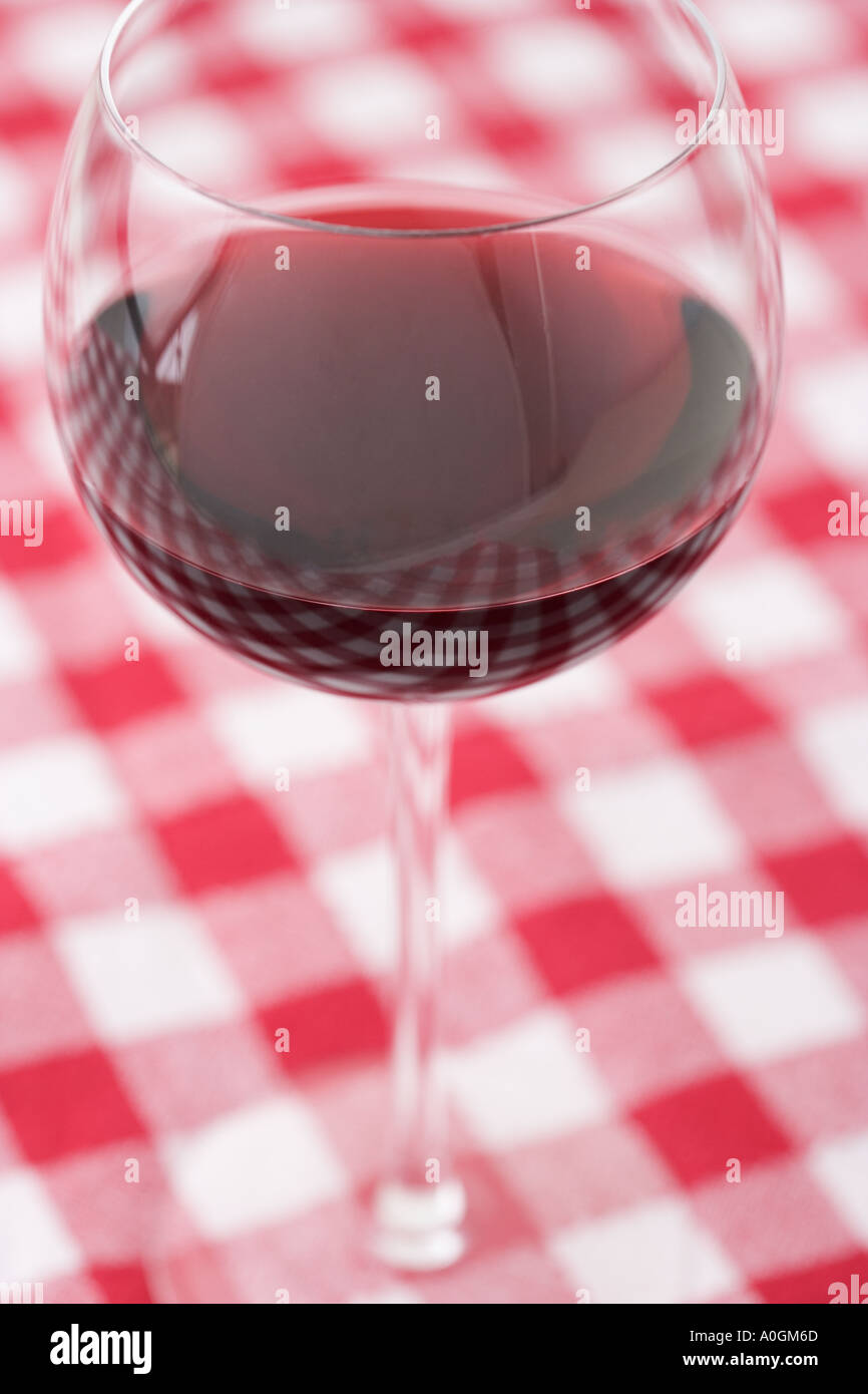Un bicchiere di vino sulla tovaglia a scacchi Foto Stock