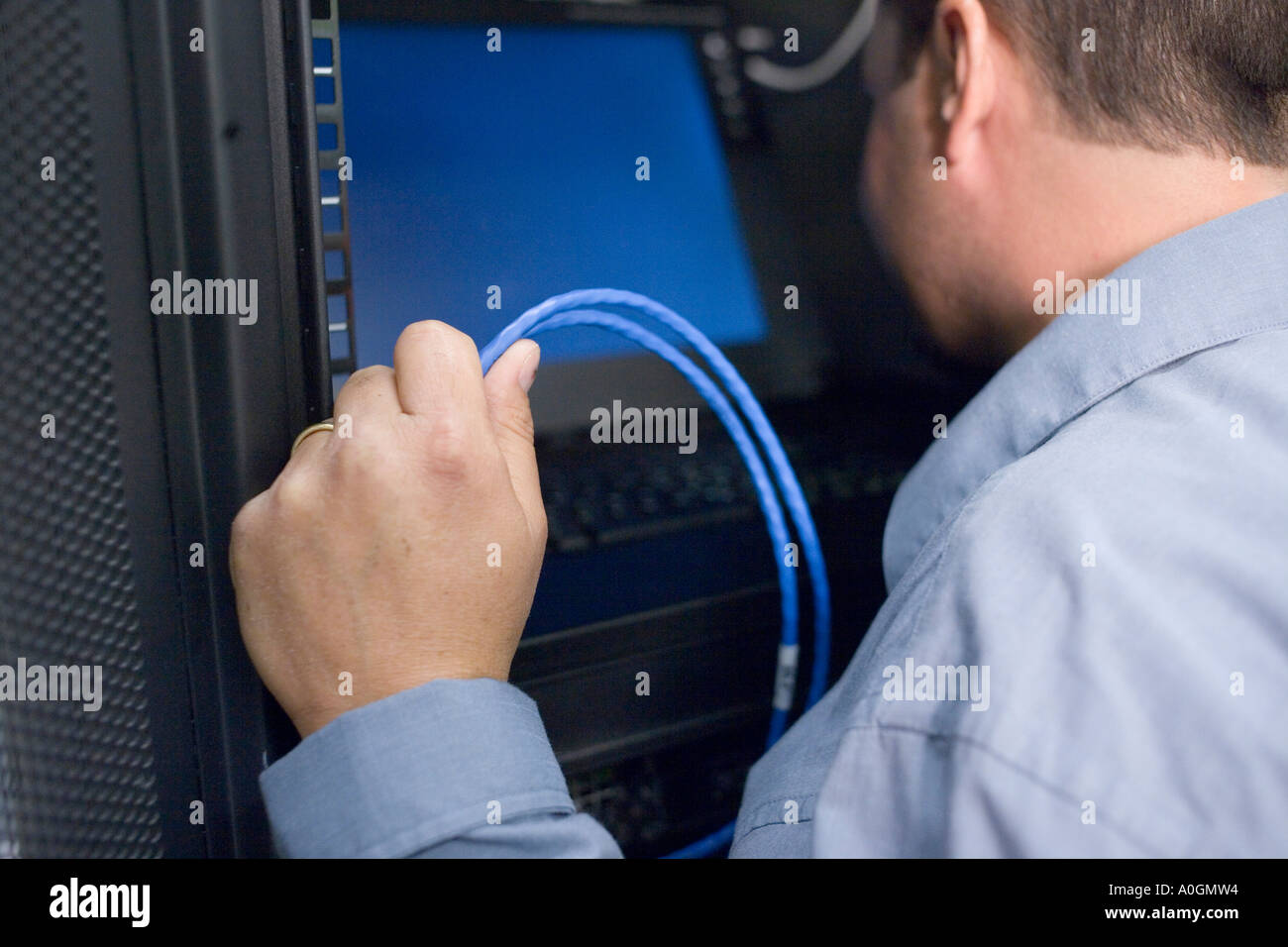 Close-up di un tecnico guardando il monitor di un computer in una sala server Foto Stock
