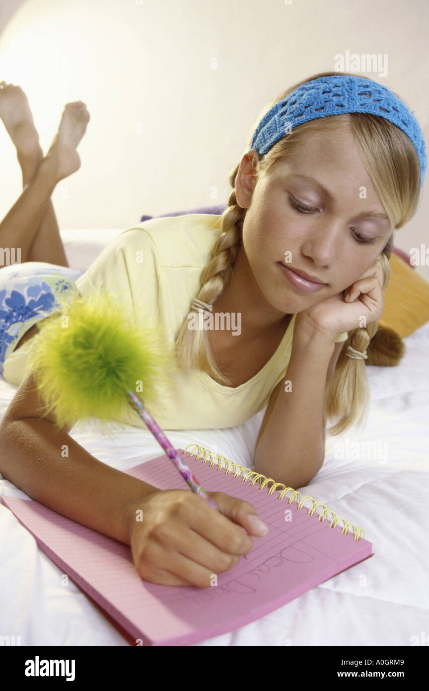 Ragazza adolescente iscritto in un notebook Foto Stock
