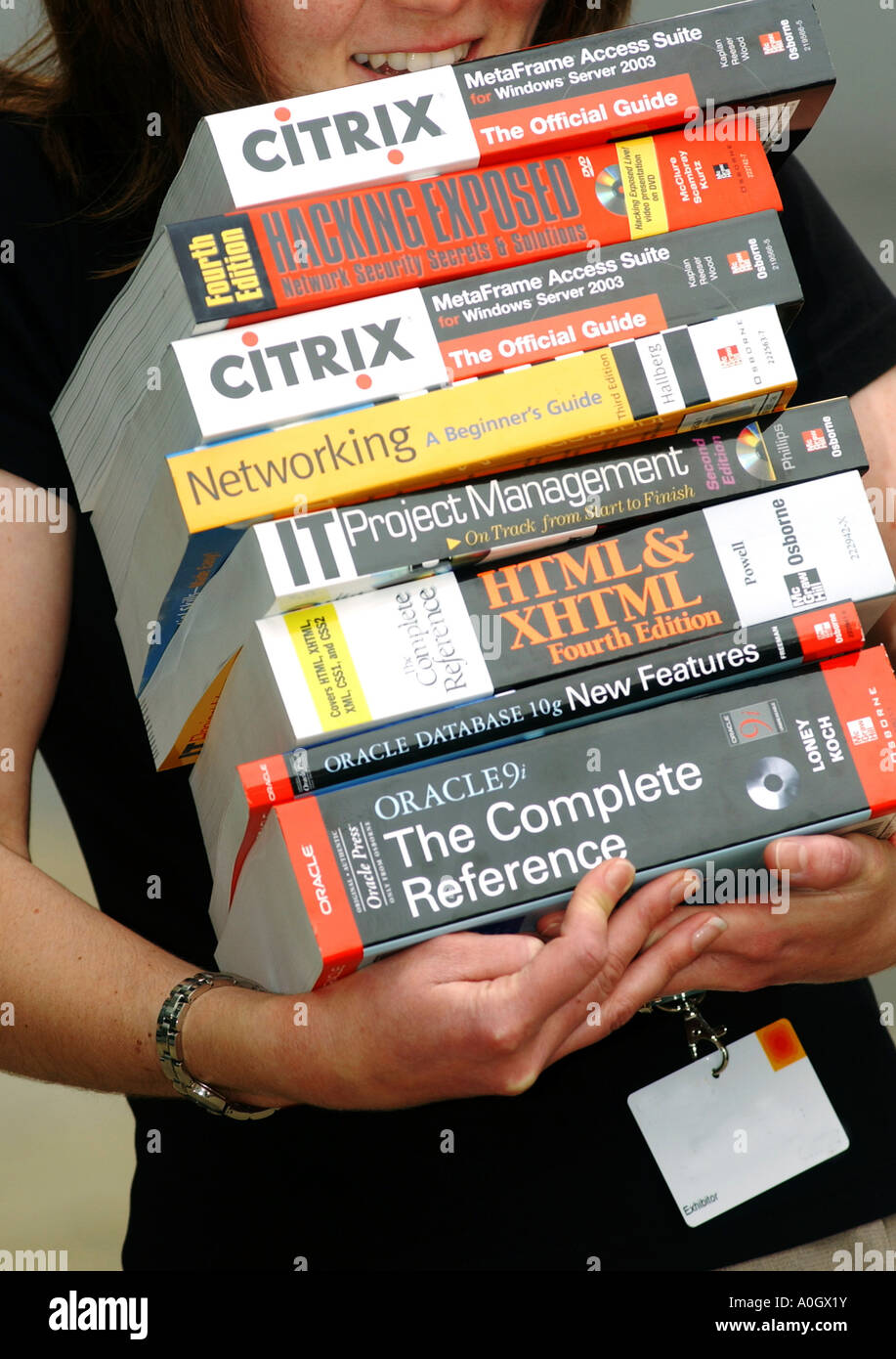 Persona che porta libri tecnici Foto Stock