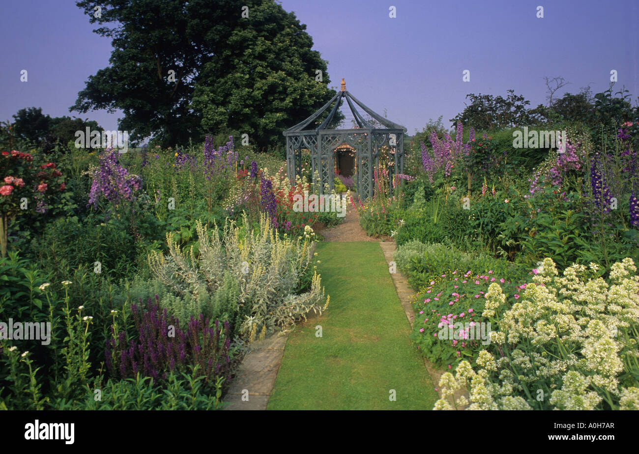 Wollerton Old Hall Shropshire percorso di erba tra frontiere erbacee che conduce al gazebo Foto Stock