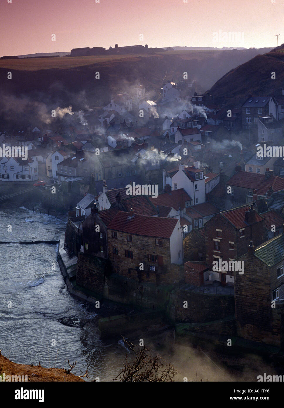 Staithes villaggio di pescatori in inverno mattina con fumo accartocciamento, North Yorkshire Coast Inghilterra Foto Stock
