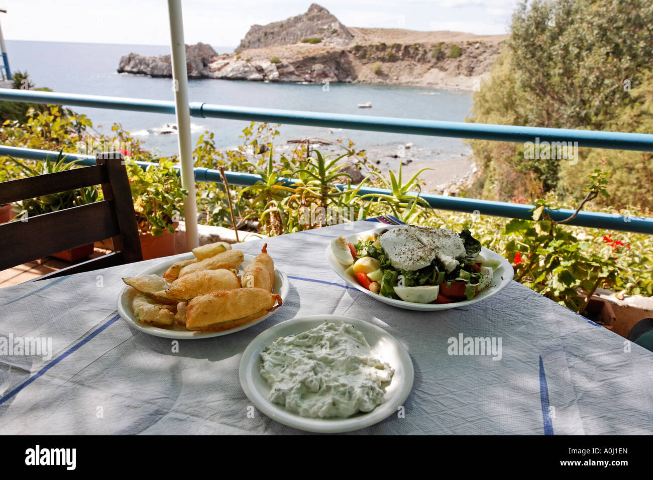 Antipasti tipici nella taverna Agios Pavlos (zucchine fritte zucchine, tzatziki, insalata cretese), il sud di Creta, Grecia Foto Stock