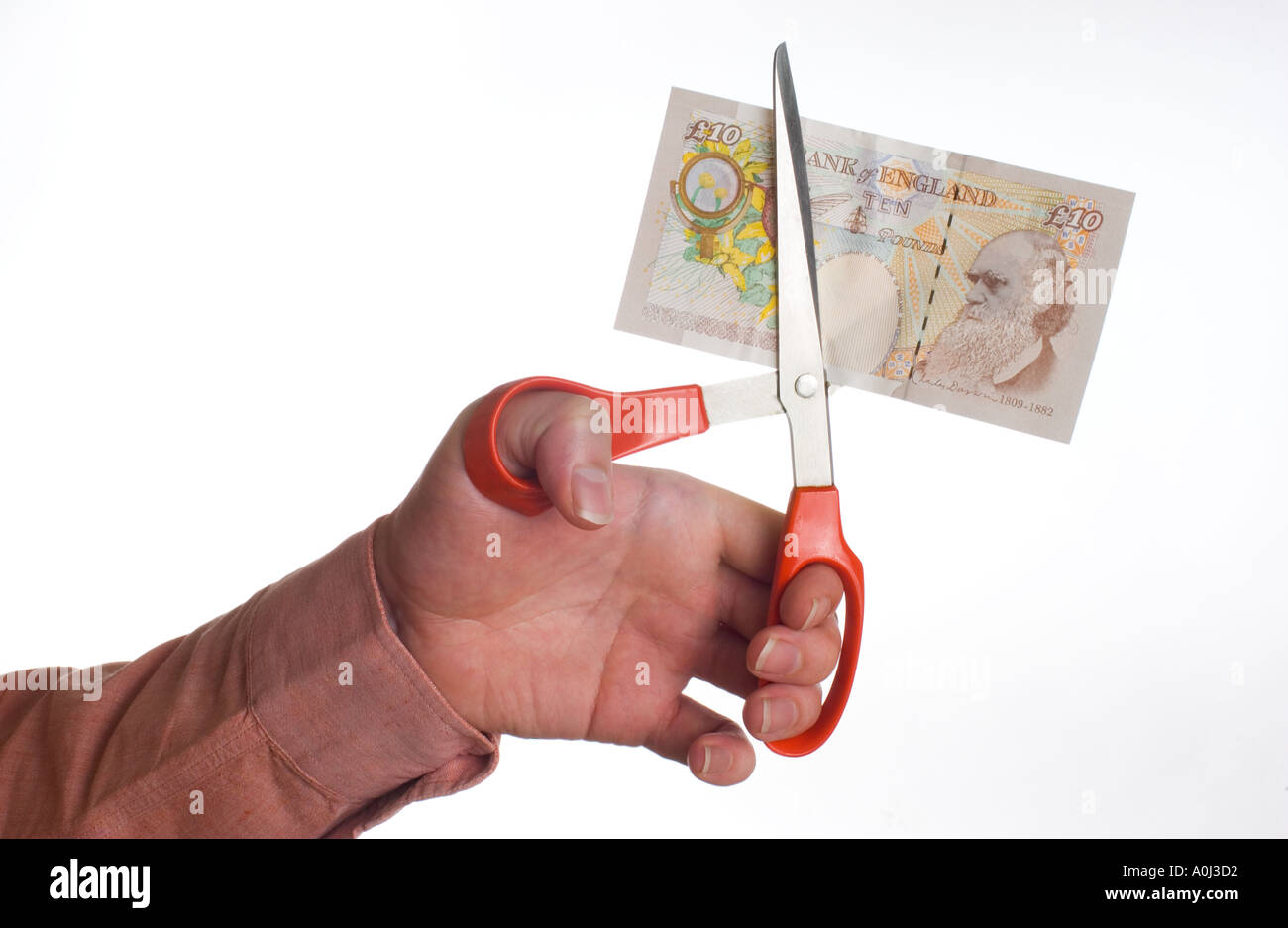 Il taglio di una banconota con un paio di forbici Foto Stock