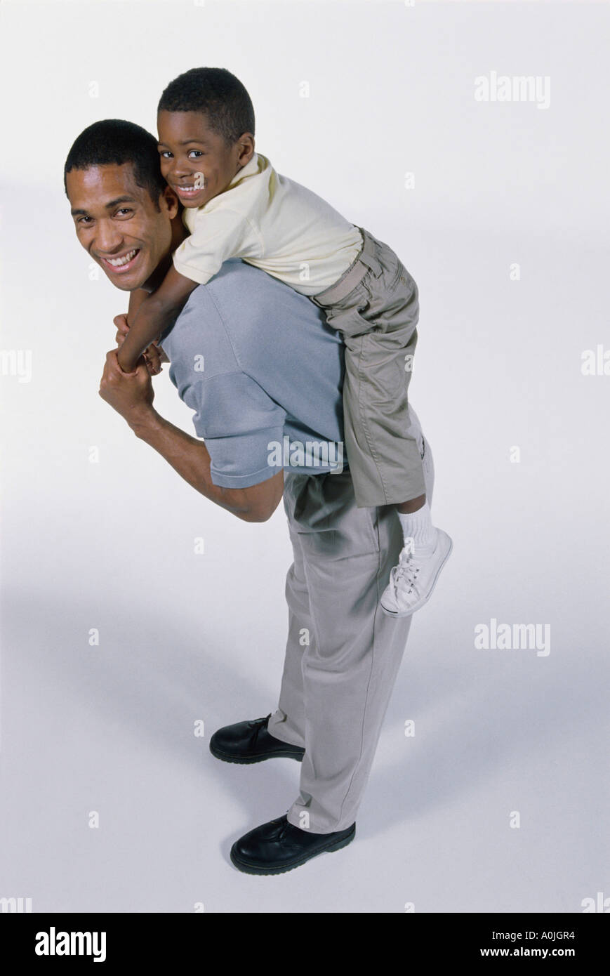 Ritratto di un padre che porta il suo figlio sulla sua schiena Foto Stock