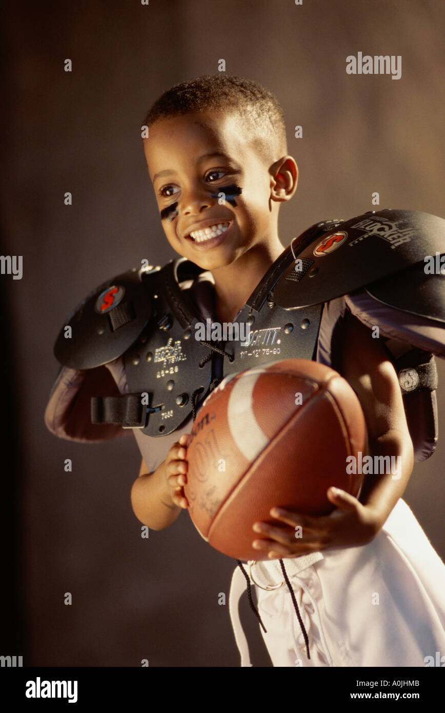 Ragazzo in un campo di calcio uniforme tenendo una palla Foto Stock