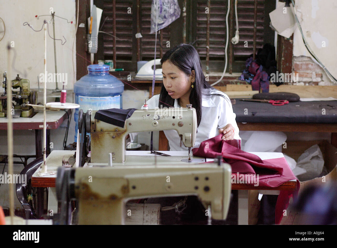 Un lavoratore indumenti da cucire in una fabbrica di seta in Hoi An Vietnam Foto Stock